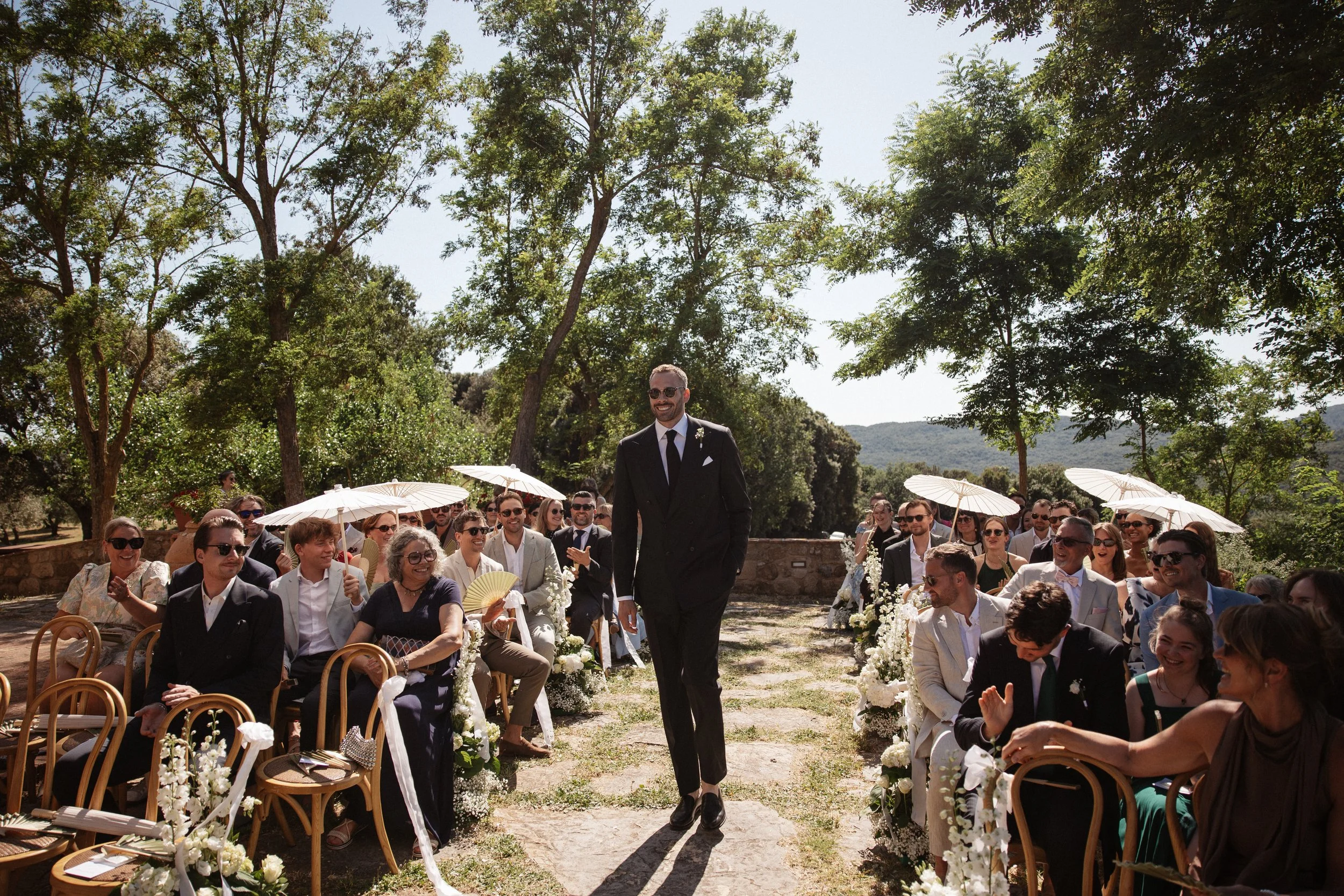 Elegant Tuscany wedding ceremony at Pieve di San Giovanni in Lustignano, surrounded by the Italian countryside, natural greenery and close family and friends.