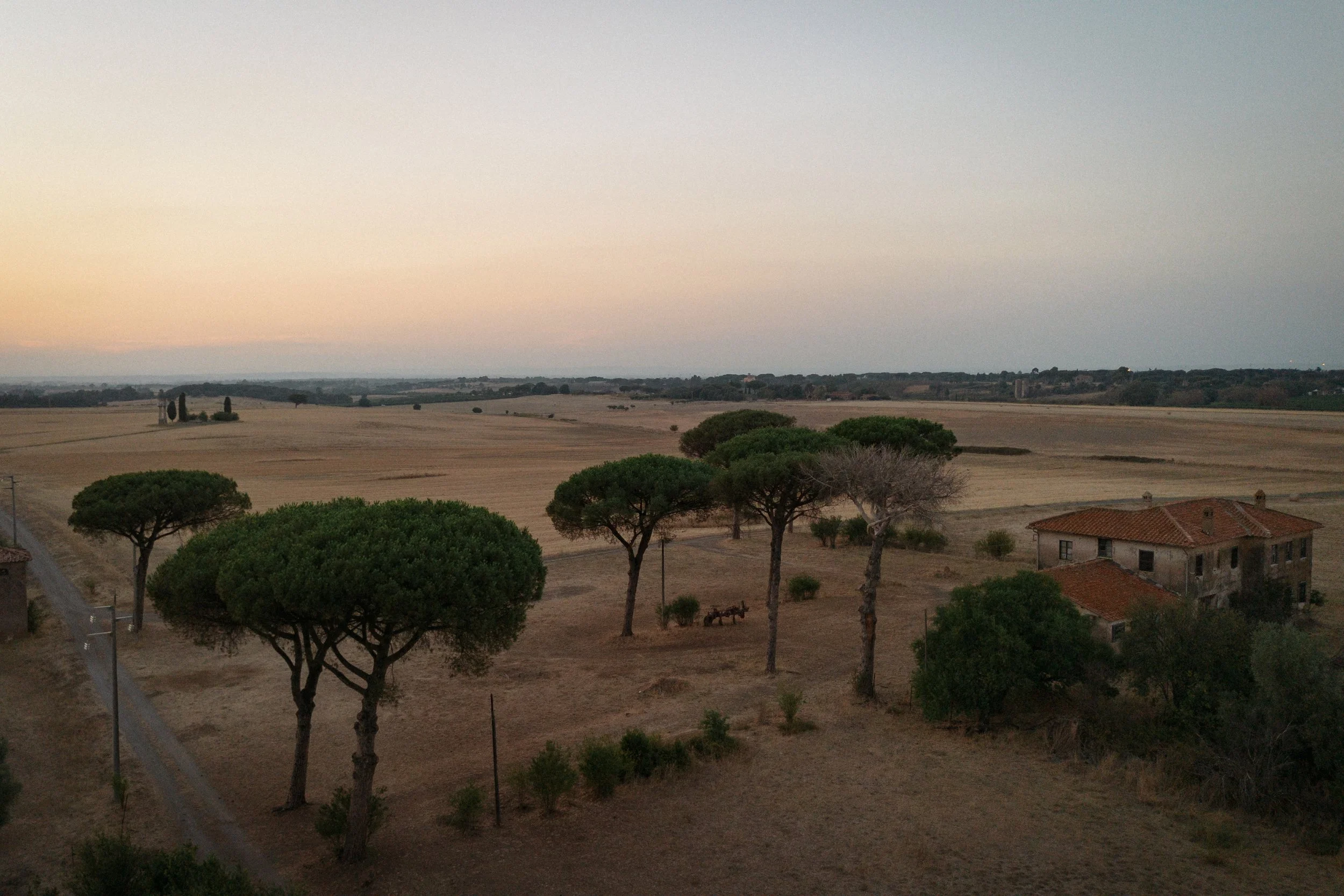 Relaxed welcome dinner at Casale del Gallo in Rome, with Selina and Jamie celebrating with their guests over pizza on a warm Italian summer evening.