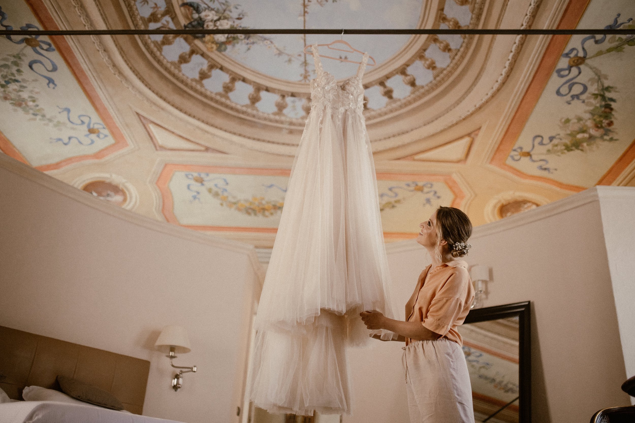 Getting Ready for Bride and Groom in the Hotel Room of Relais Sant Uffzie in Piedmont, Italy. Wooden Chairs and Vintage Metal Wedding Arch decorated with Eucalyptus and White Fabric.