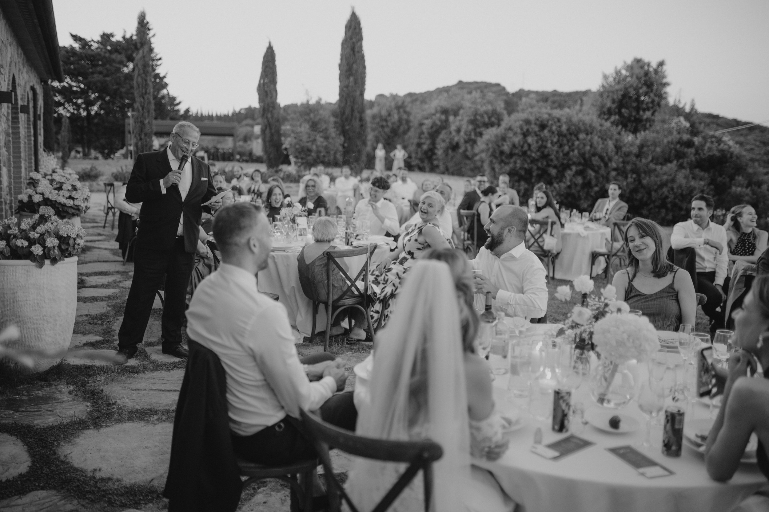 Relaxed and elegant Tuscany wedding dinner under the open sky, with natural white and green wedding styling, long summer evenings and an intimate atmosphere.