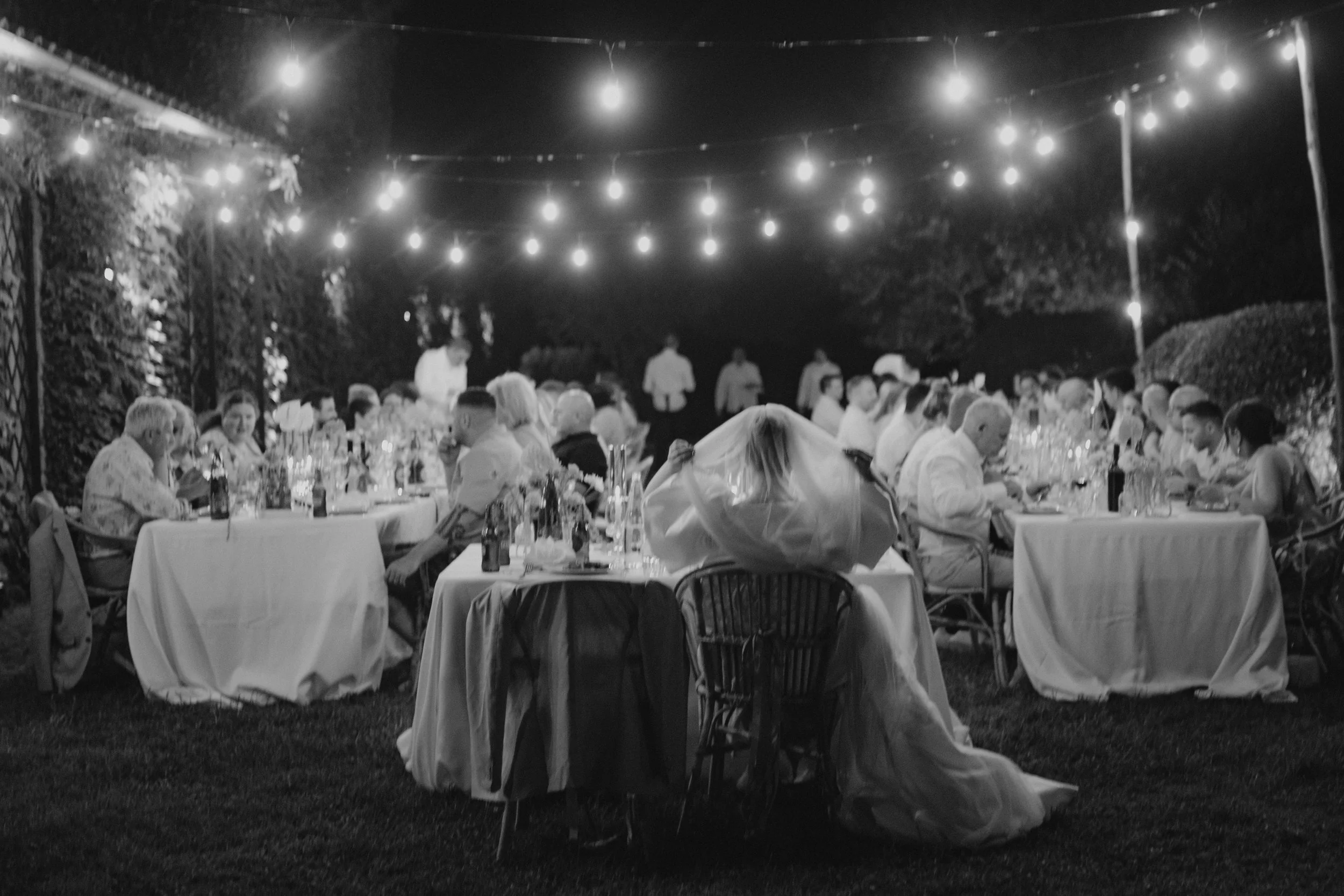 Elegant destination wedding dinner and couple portraits at Casale del Gallo near Rome, with long outdoor tables, natural floral styling and warm Italian evening light.