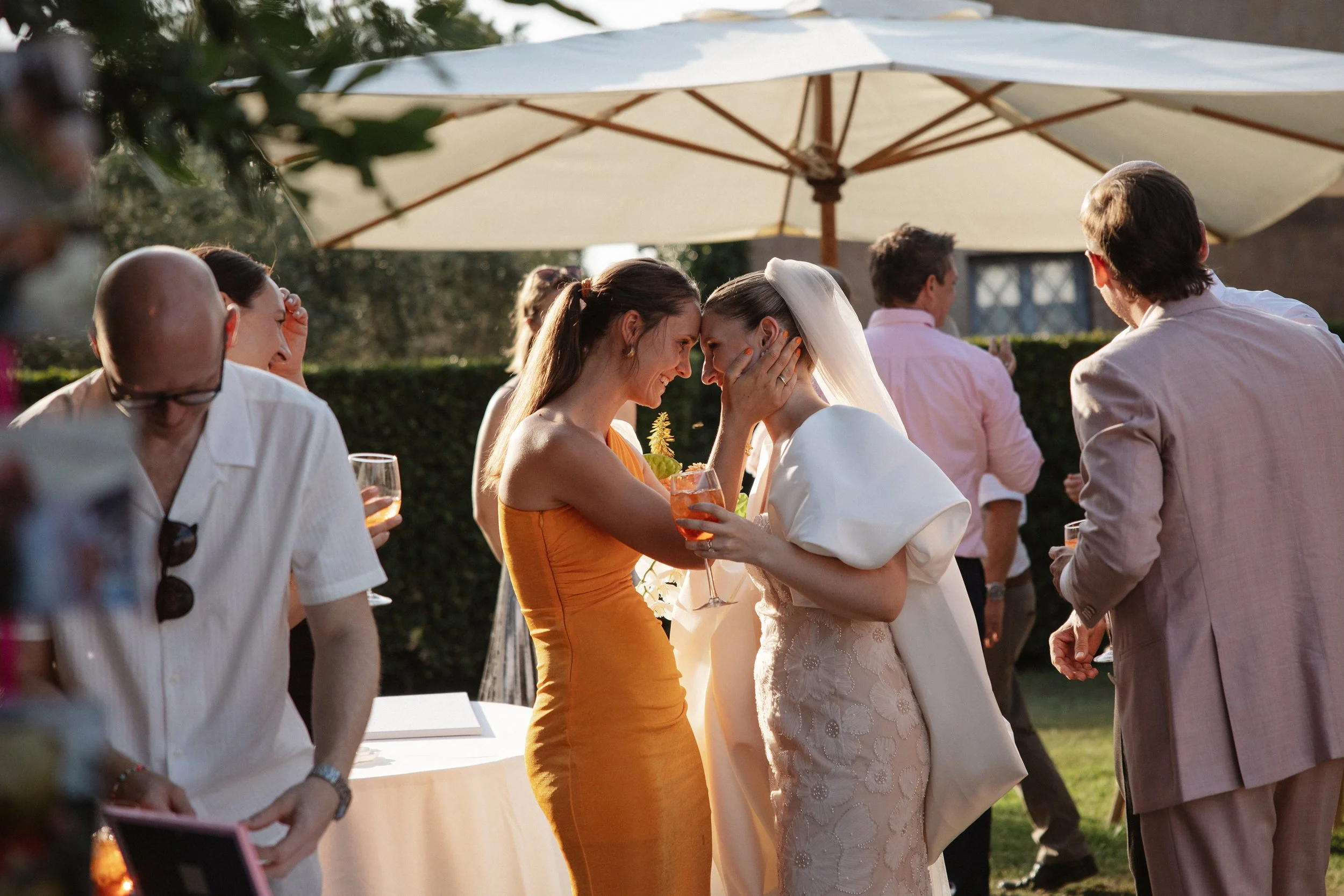 Italian summer wedding at Casale del Gallo near Rome, featuring Selina’s individual wedding dress by Lieben Achten Ehren, her statement cape and Jamie’s rose-colored suit.