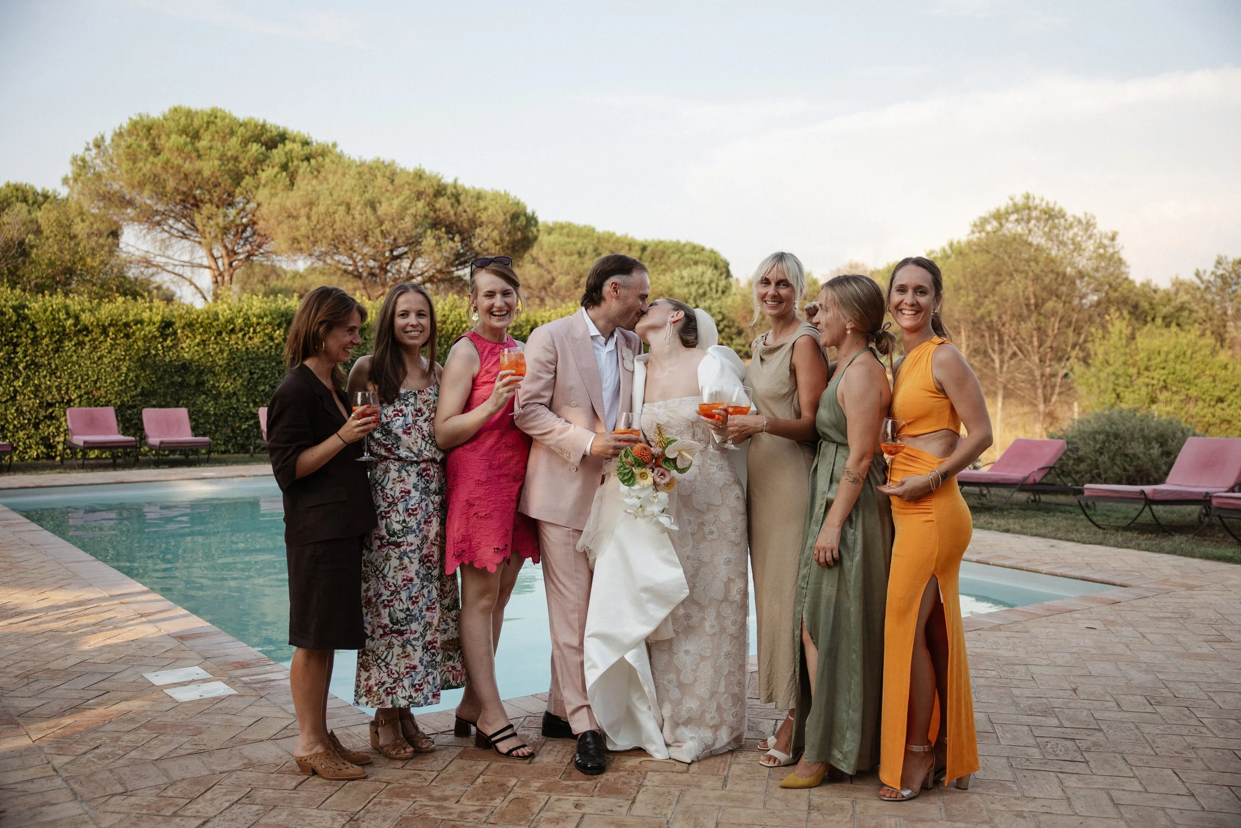 Italian summer wedding at Casale del Gallo near Rome, featuring Selina’s individual wedding dress by Lieben Achten Ehren, her statement cape and Jamie’s rose-colored suit.