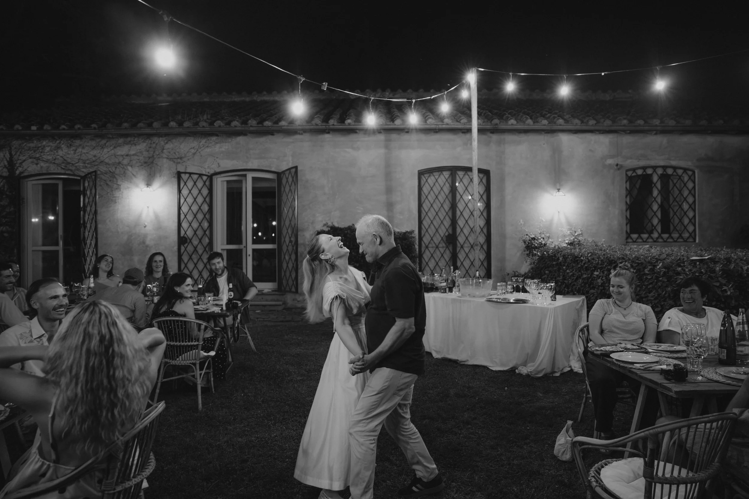 Relaxed welcome dinner at Casale del Gallo in Rome, with Selina and Jamie celebrating with their guests over pizza on a warm Italian summer evening.