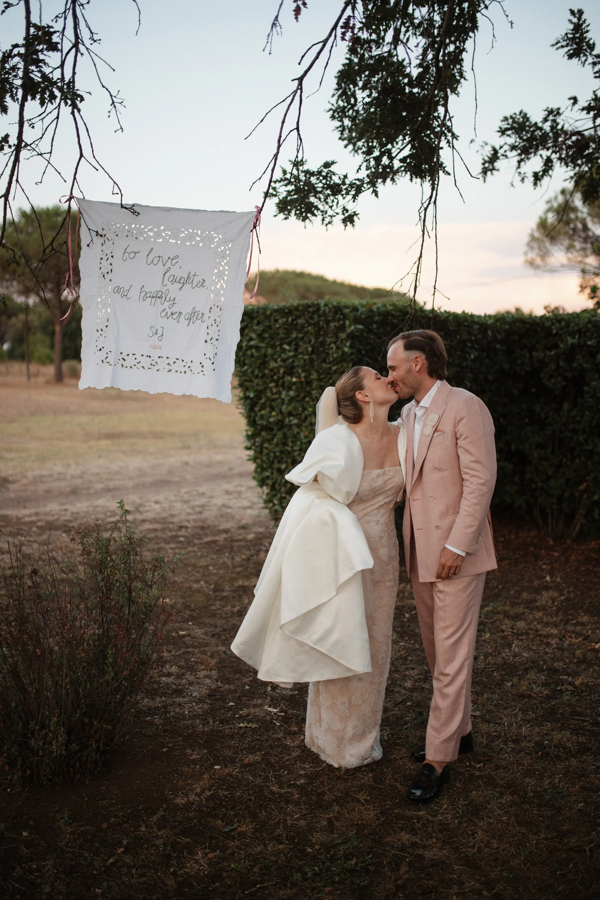 Elegant destination wedding dinner and couple portraits at Casale del Gallo near Rome, with long outdoor tables, natural floral styling and warm Italian evening light.