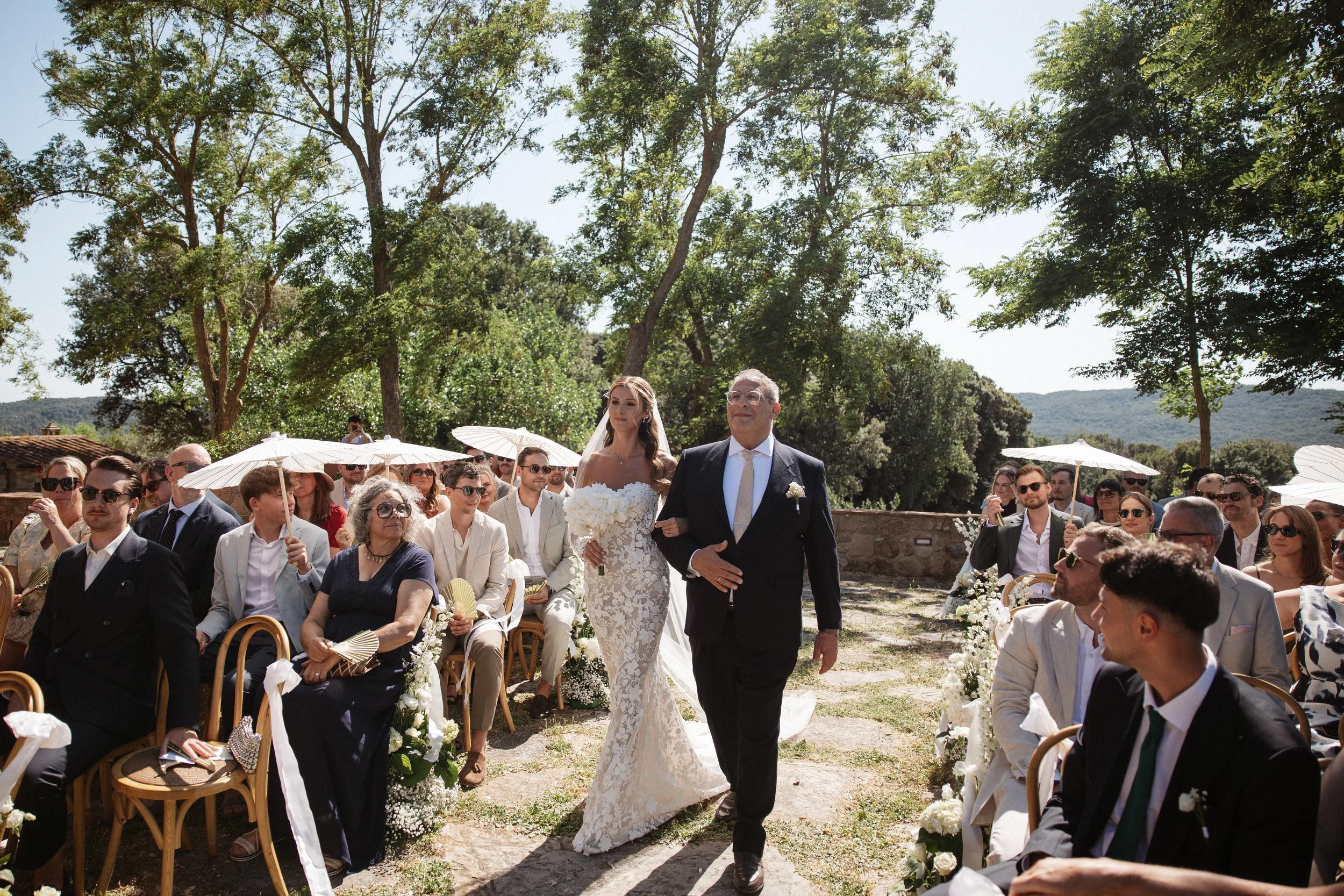 Elegant Tuscany wedding ceremony at Pieve di San Giovanni in Lustignano, surrounded by the Italian countryside, natural greenery and close family and friends.