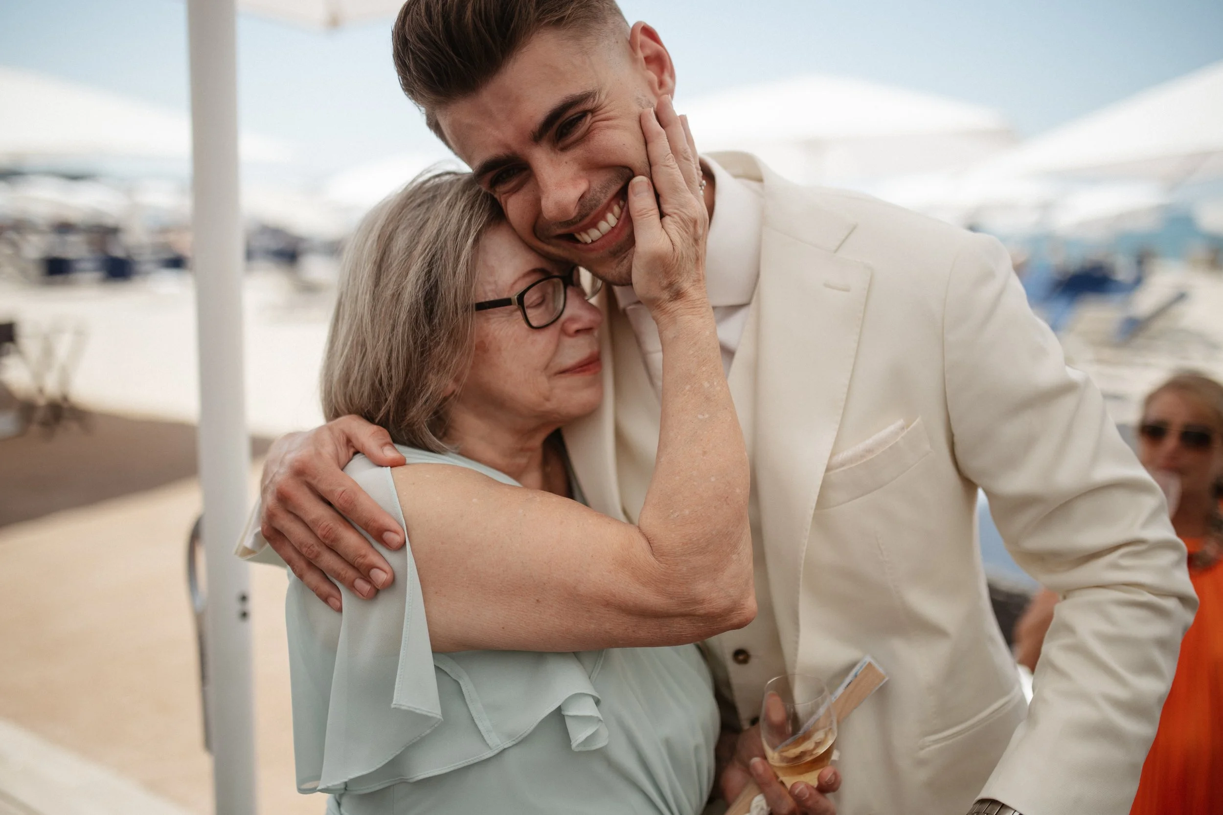 Outdoor wedding ceremony at Stephanie Beach in Cannes overlooking the Mediterranean Sea, surrounded by palm trees and the beautiful coastline of the French Riviera during an intimate luxury wedding.