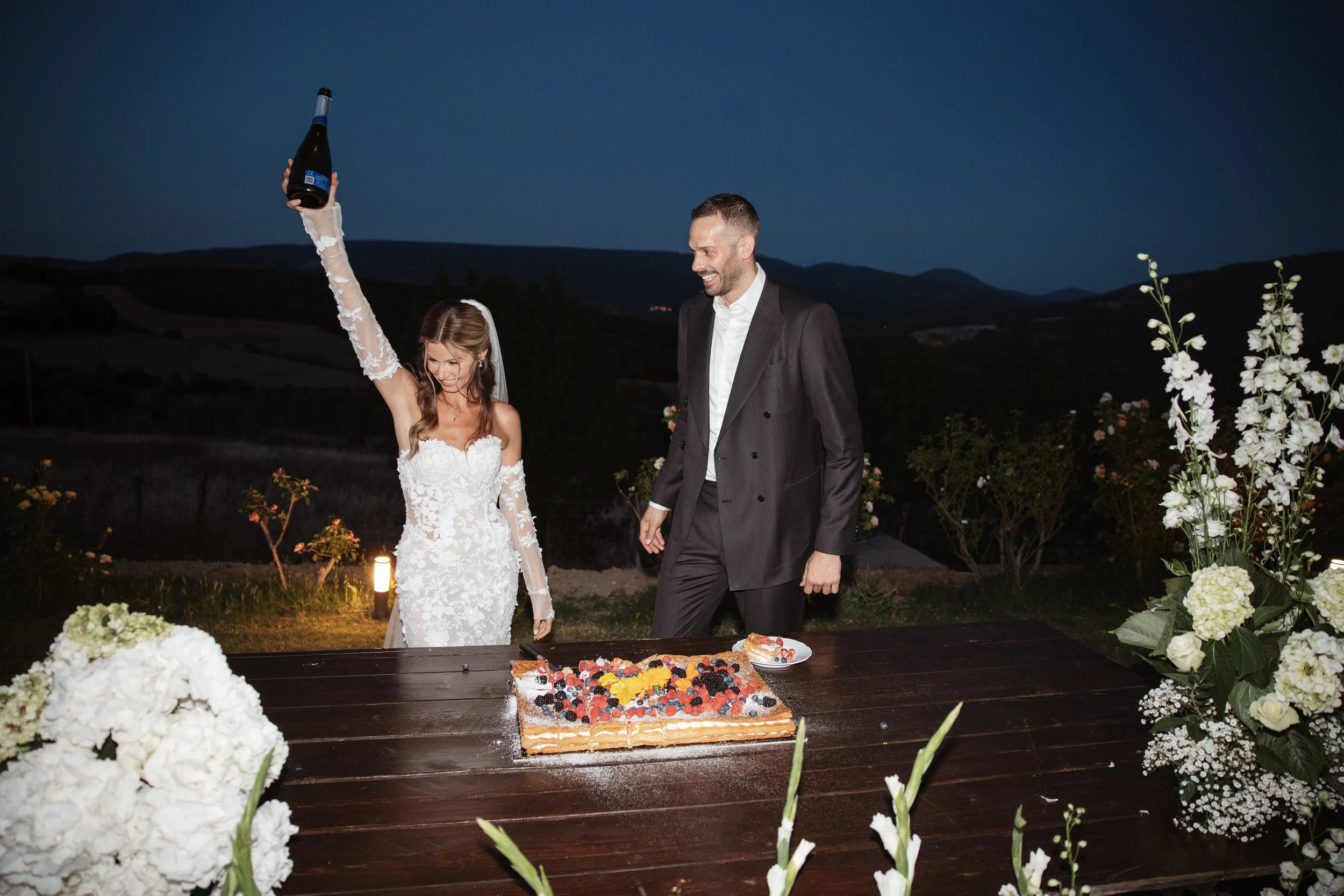 Relaxed and elegant Tuscany wedding dinner under the open sky, with natural white and green wedding styling, long summer evenings and an intimate atmosphere.
