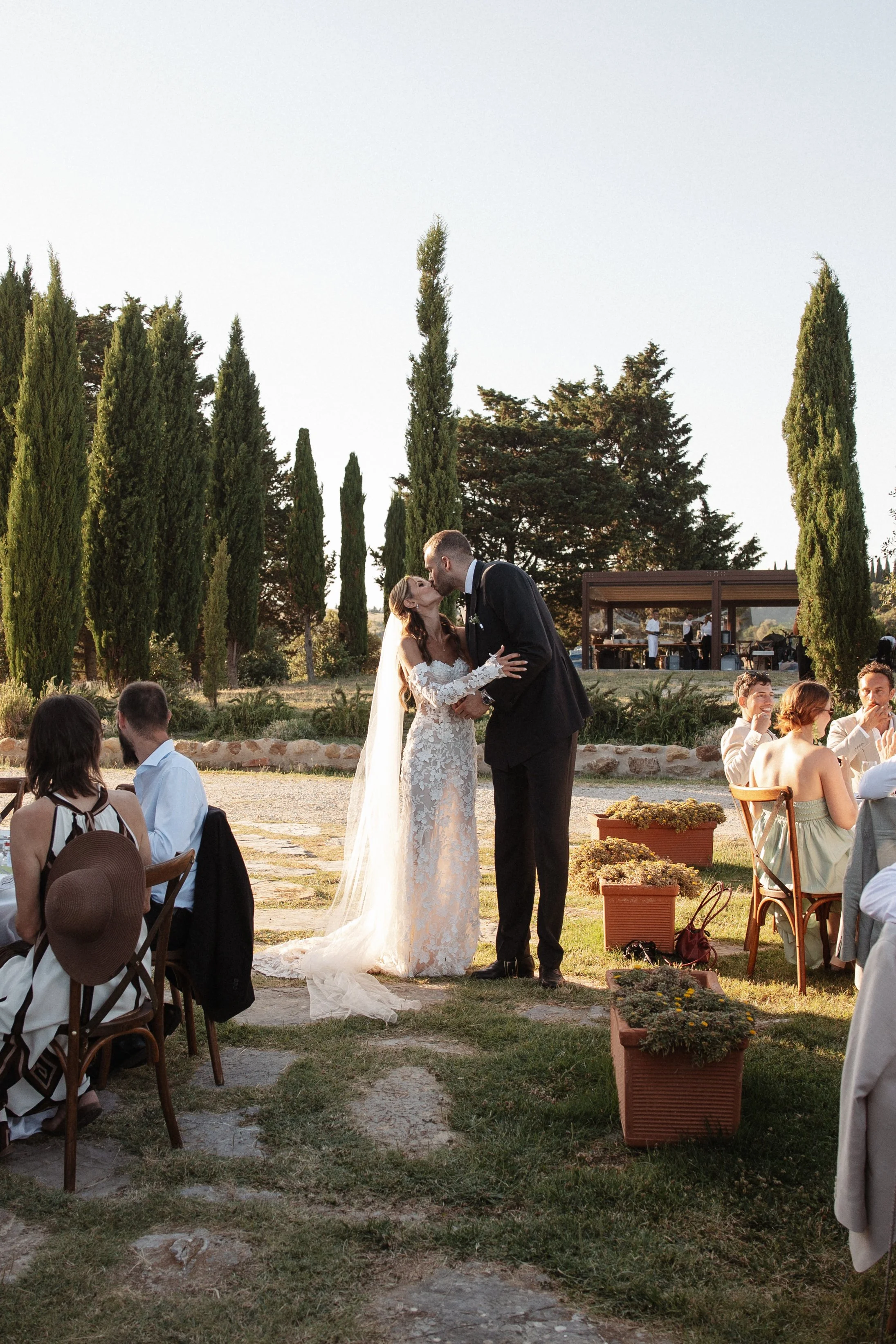 Relaxed and elegant Tuscany wedding dinner under the open sky, with natural white and green wedding styling, long summer evenings and an intimate atmosphere.