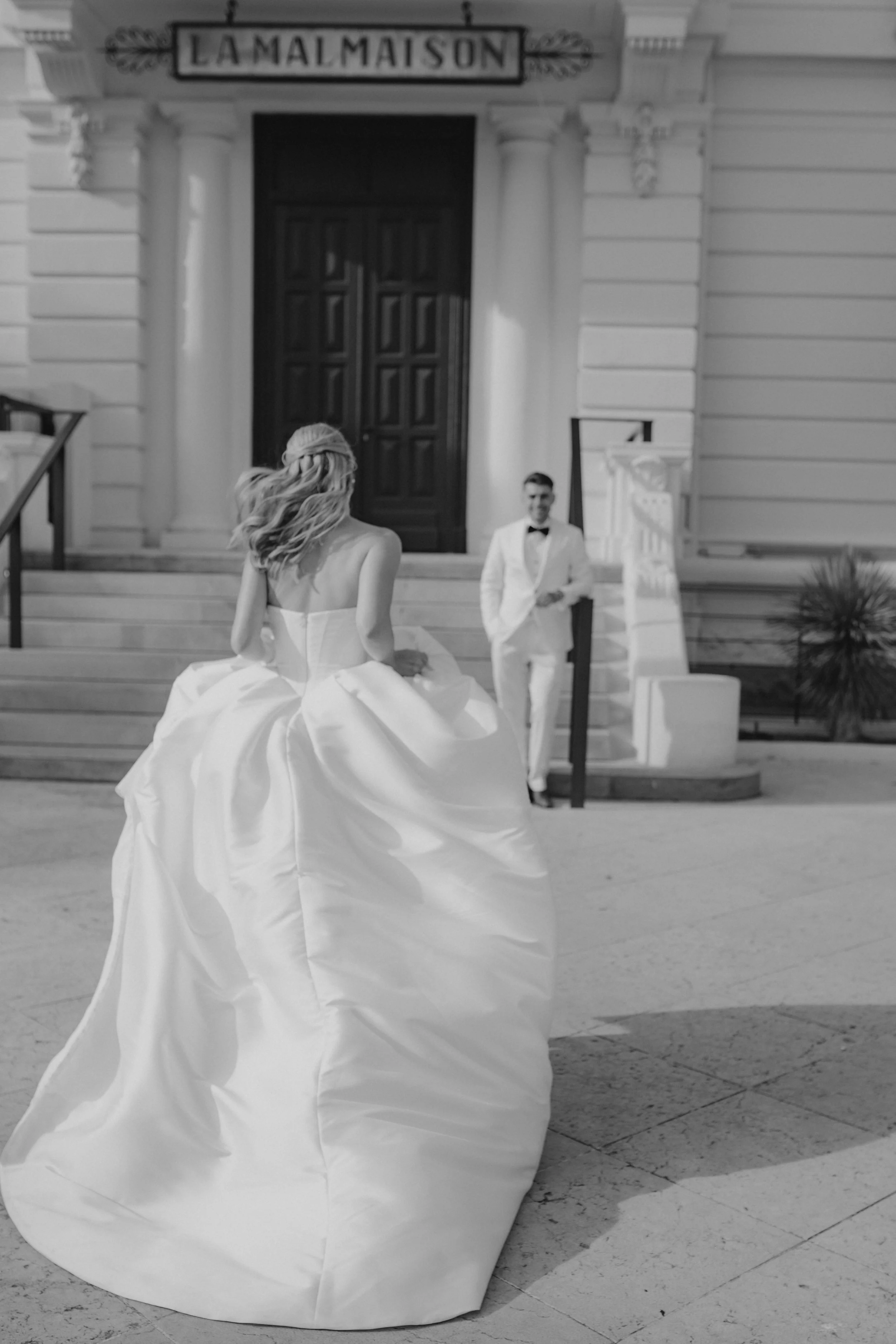 Elegant wedding portraits of the bride and groom along Boulevard de la Croisette in Cannes, featuring a white tuxedo, timeless bridal fashion, Mediterranean architecture, and the iconic French Riviera atmosphere.