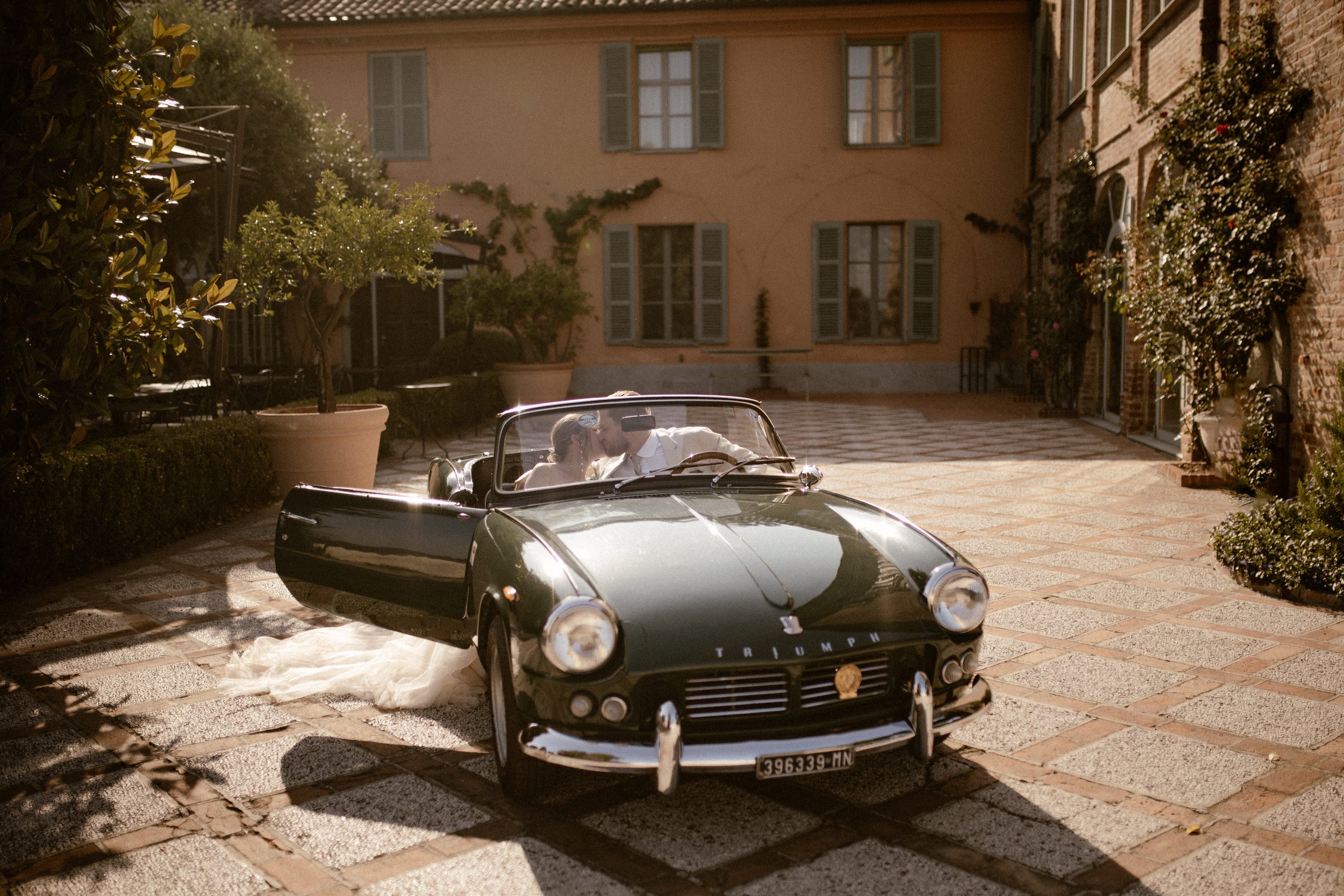 Wedding in Italy. Wedding Photo Shoot for bride and groom with a triumph car. Modern Casual Decoration. Dinnersetting with Pergola and Fairy Lights. White, gold and eucalyptus decoration.