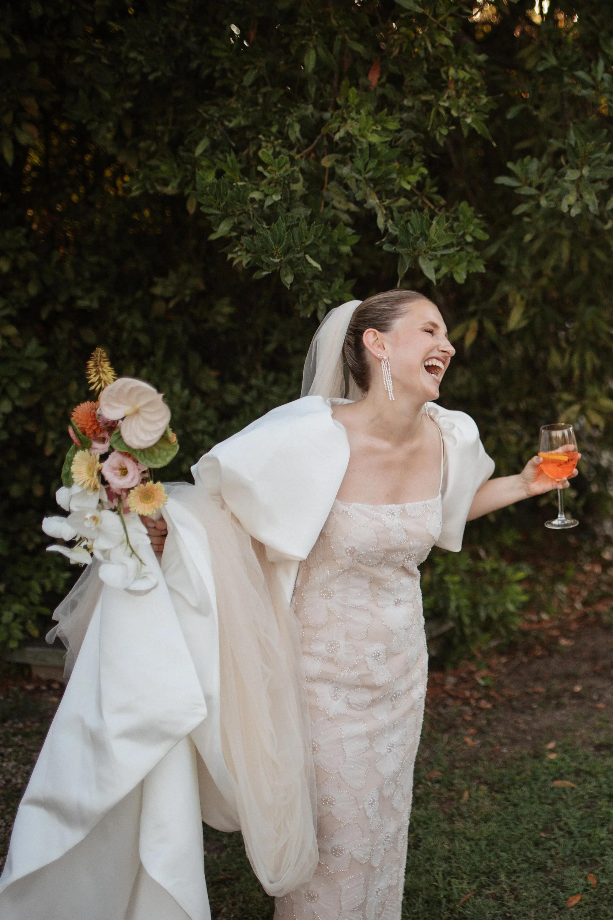 Italian summer wedding at Casale del Gallo near Rome, featuring Selina’s individual wedding dress by Lieben Achten Ehren, her statement cape and Jamie’s rose-colored suit.
