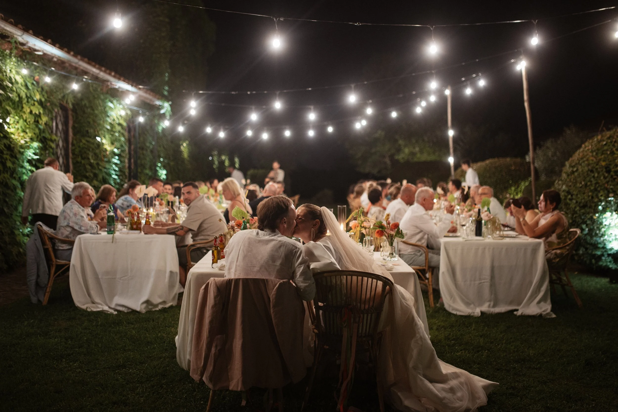 Elegant destination wedding dinner and couple portraits at Casale del Gallo near Rome, with long outdoor tables, natural floral styling and warm Italian evening light.