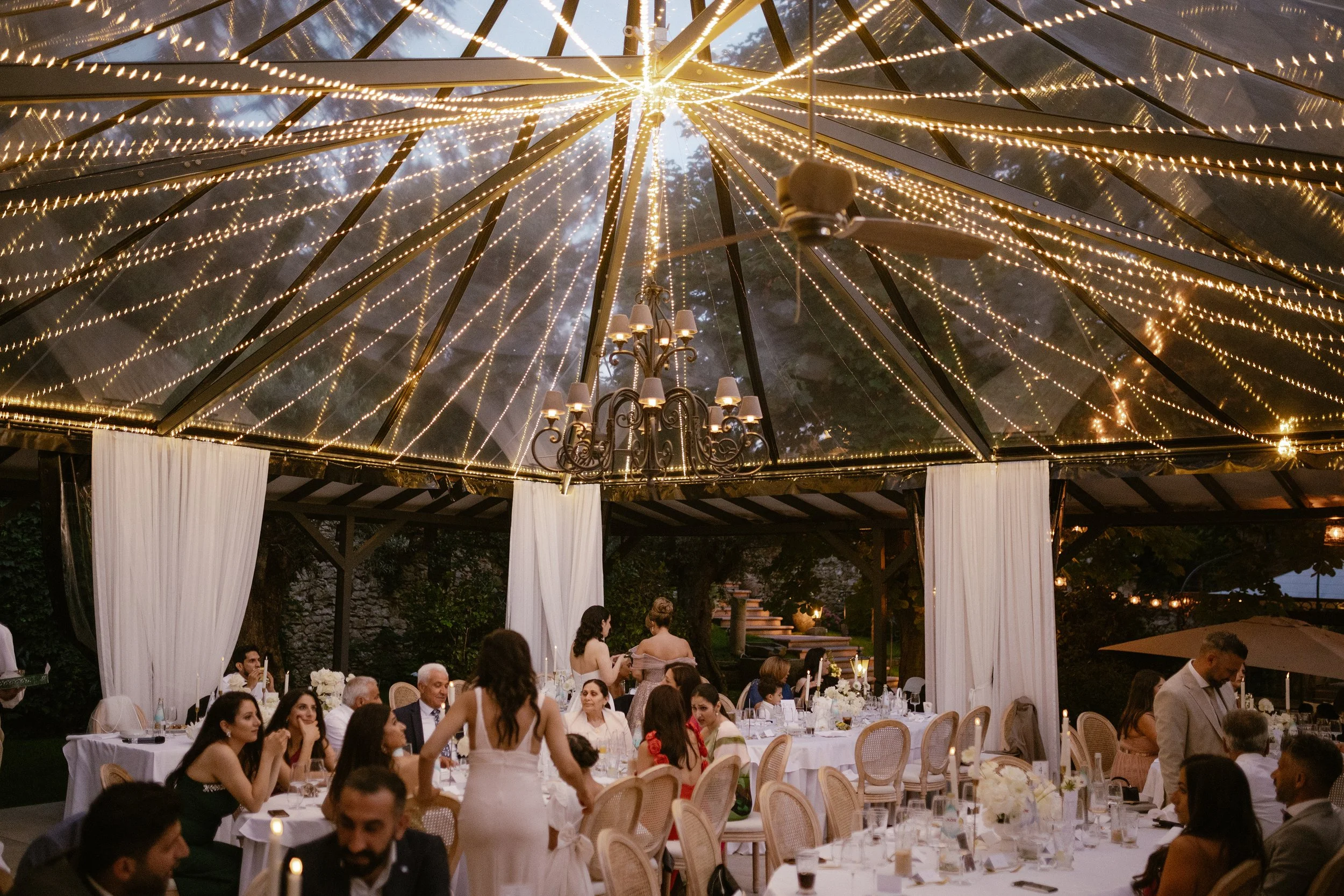 A joyful summer afternoon at the exclusive Morrhof Piazza Toscana, where celebration begins early. Surrounded by warm sunlight, guests gather for music, dancing and heartfelt moments. The iconic first dance on the pool creates a striking contrast of 
