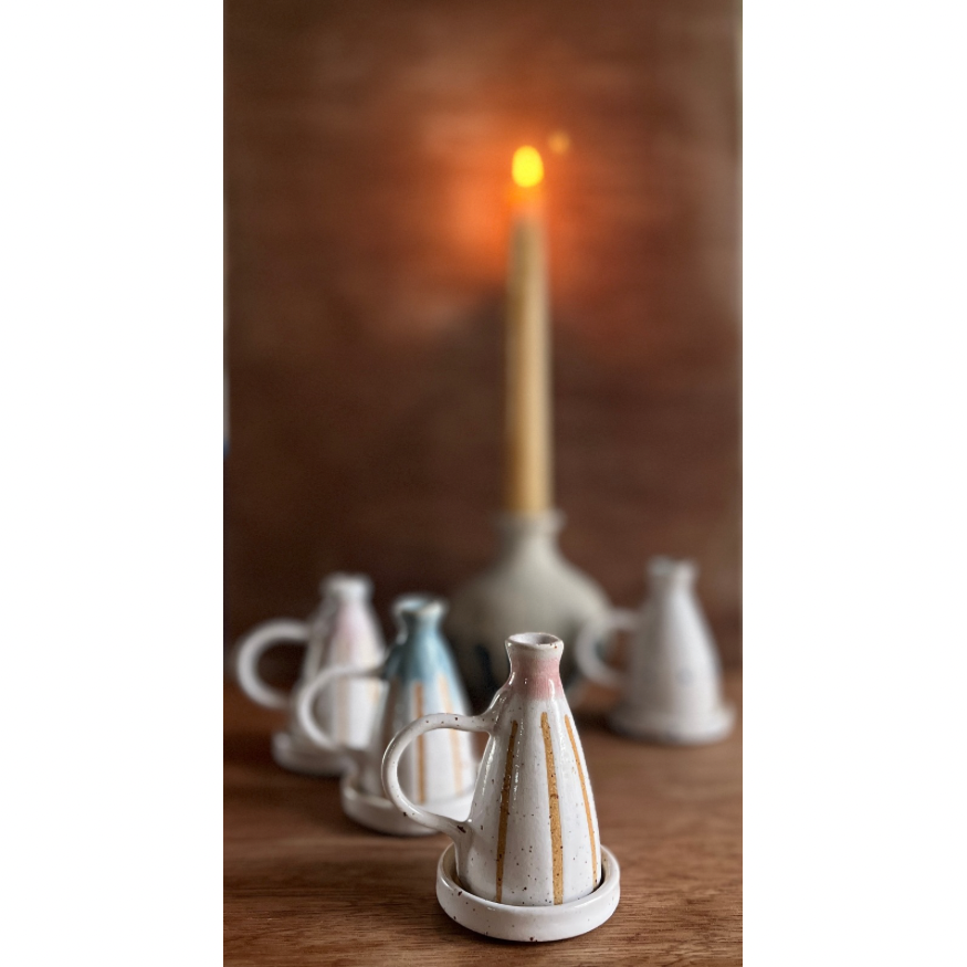 ceramic candle snuffers with a blurred, lit candle in a vase in the background