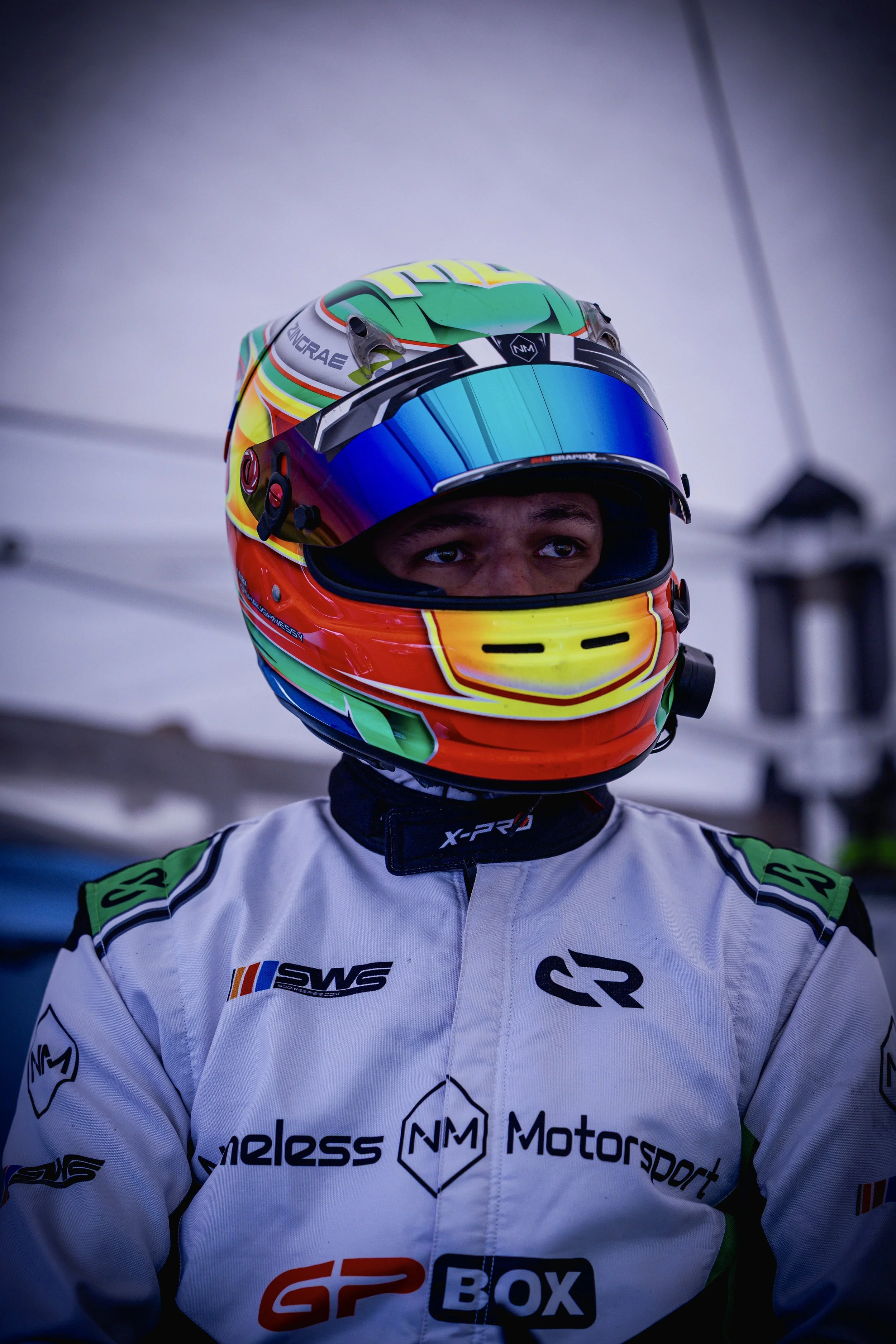 Person in a colorful helmet and race suit, preparing for a karting event.