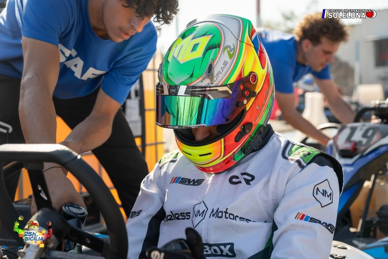 Person in a colorful helmet and race suit, preparing for a karting event.