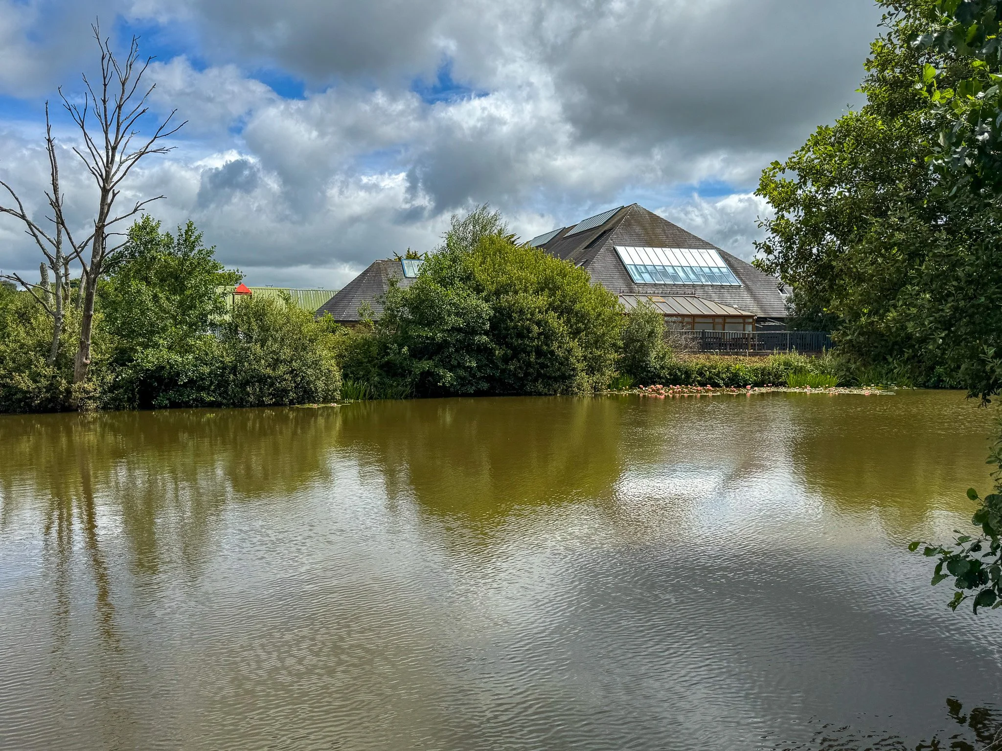 View across the fishing lake towards the clubhouse at Bodmin Holiday Park in Cornwall.