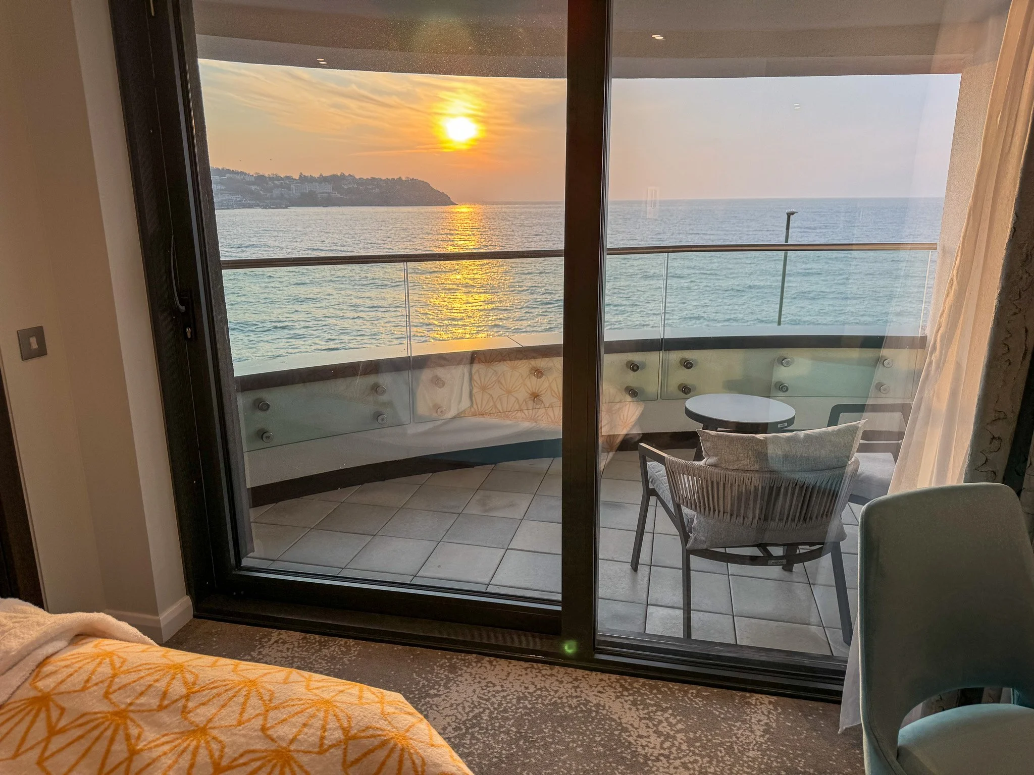 Hotel Indigo Torquay balcony sunrise sea view from bedroom with patio doors and seating