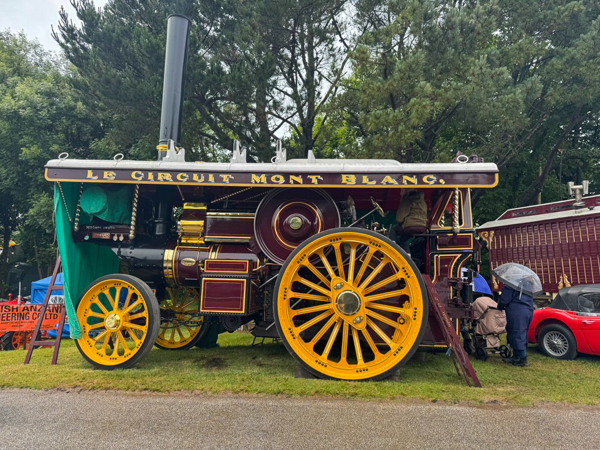 Vintage steam traction engine on display at the Royal Cornwall Show with large yellow wheels and traditional fairground-style detailing.