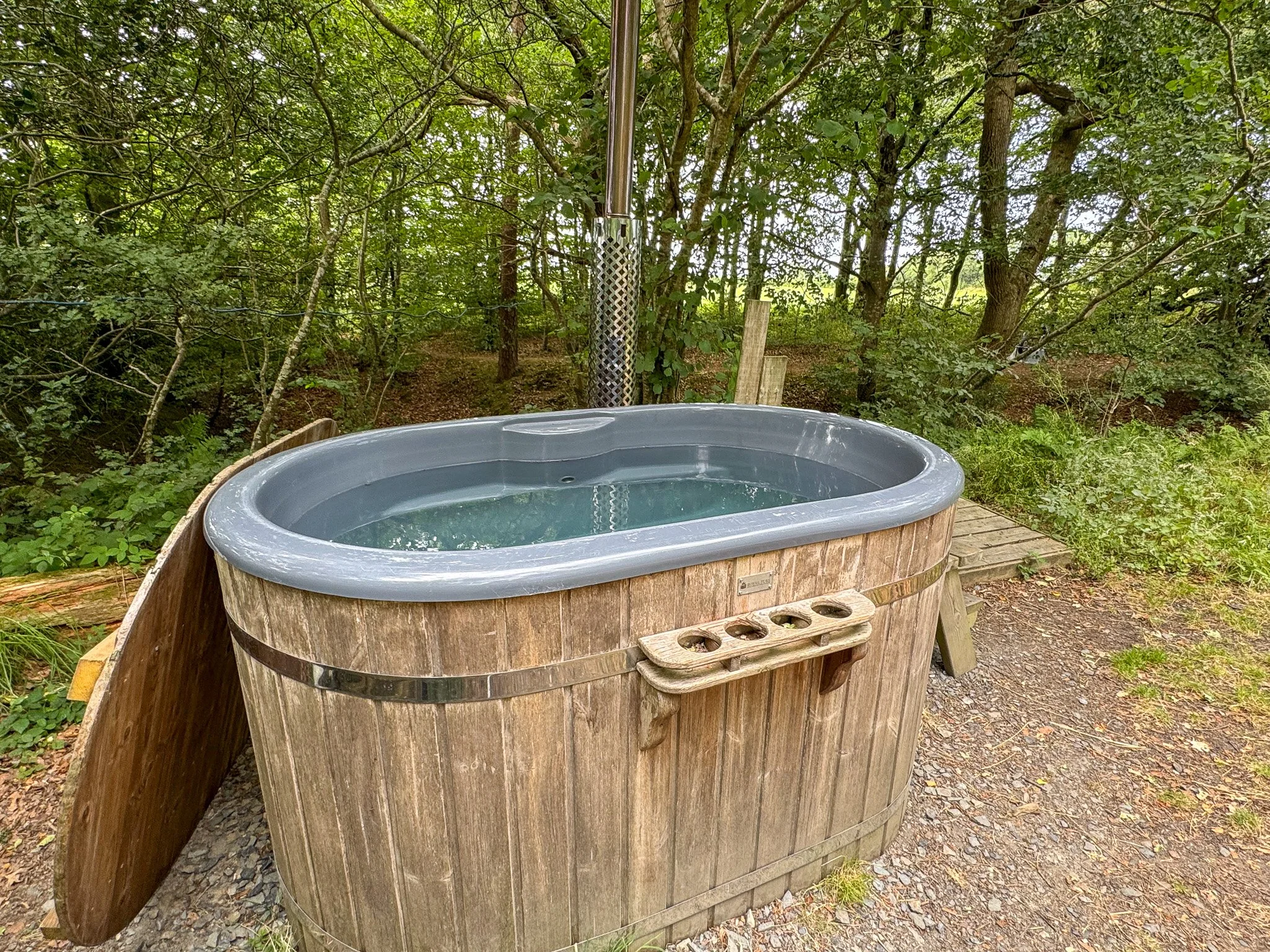 Private wood-fired hot tub surrounded by woodland at Slow Glamping in Devon.