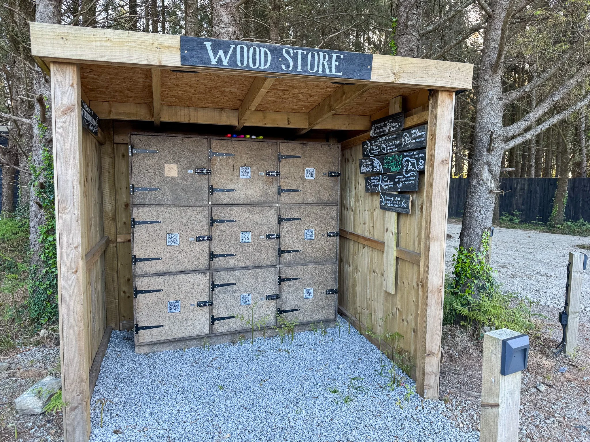 Secret Garden Glamping Cornwall firewood lockers with QR code for buying extra logs