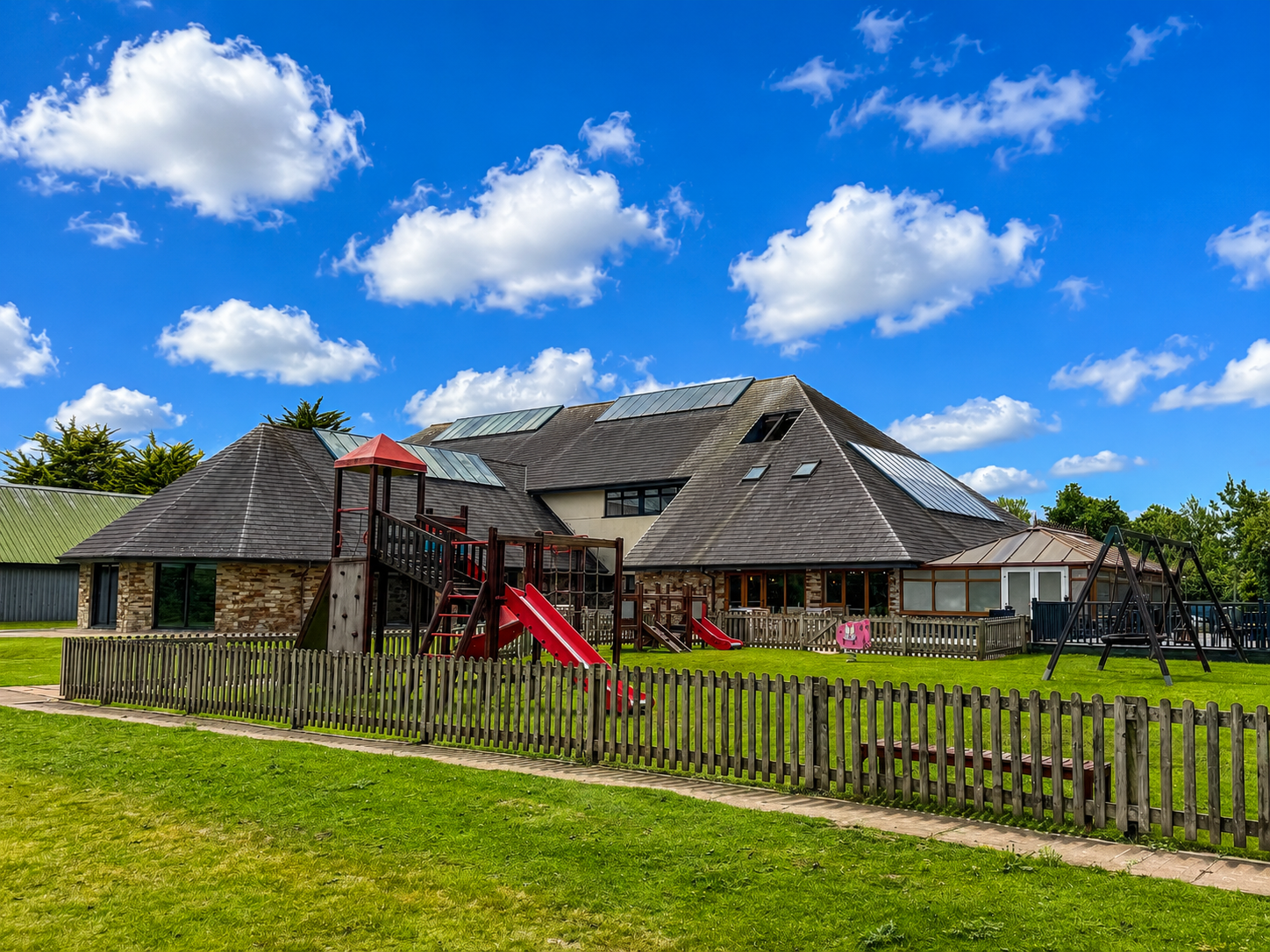 Children's outdoor play area beside the clubhouse at Bodmin Holiday Park in Cornwall.