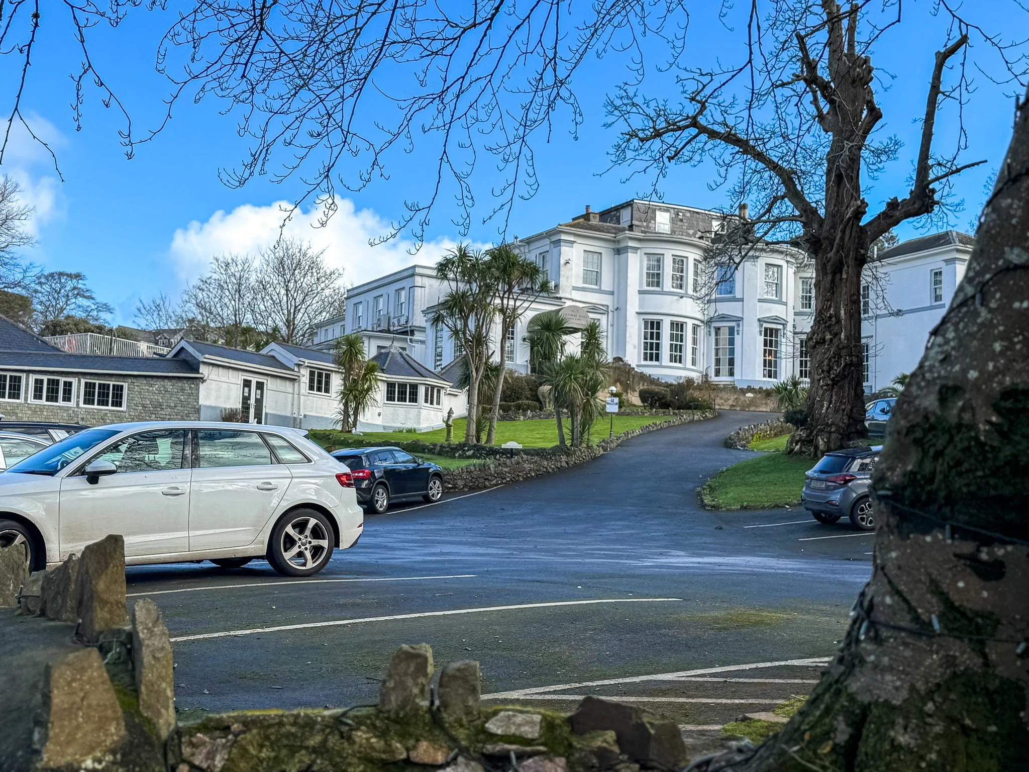 Main entrance and historic facade of the adults-only Lincombe Hall Hotel and Spa, showcasing the elegant white architecture and landscaped gardens in the English Riviera.