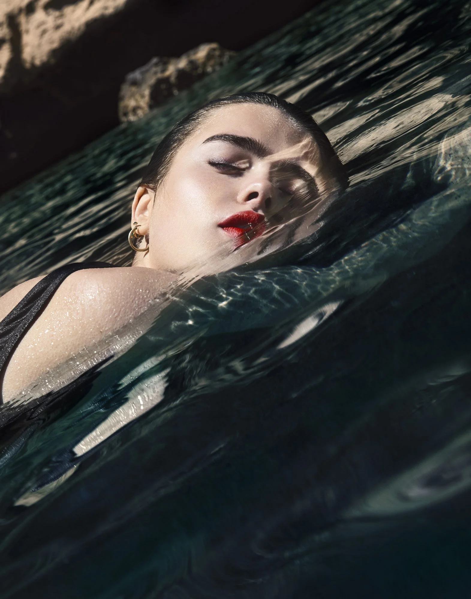 Red lipstick in water, editorial beauty photography by Benjamin Kaufmann