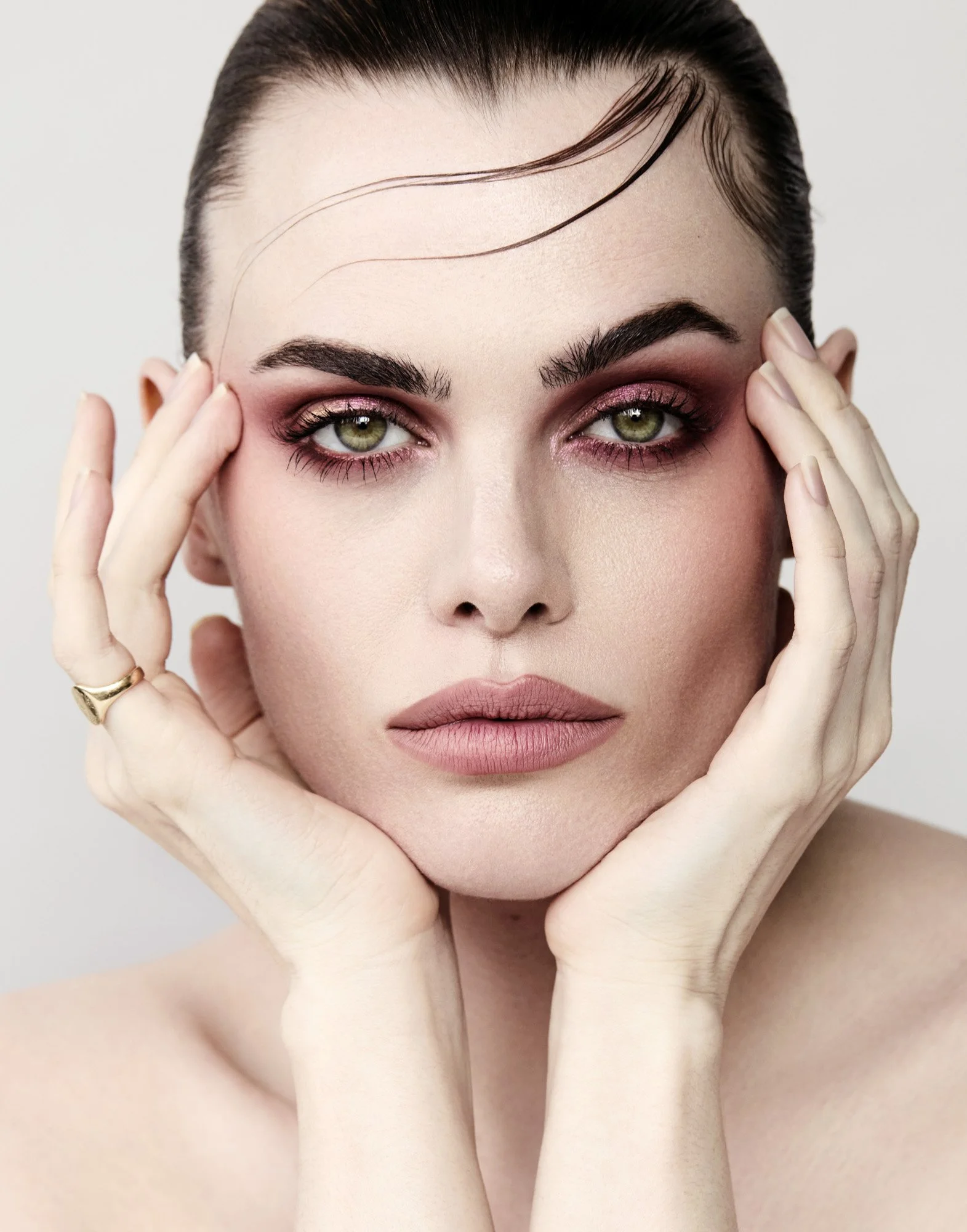 Berry eyeshadow and green eyes, hands framing the face, beauty photographer London Benjamin Kaufmann