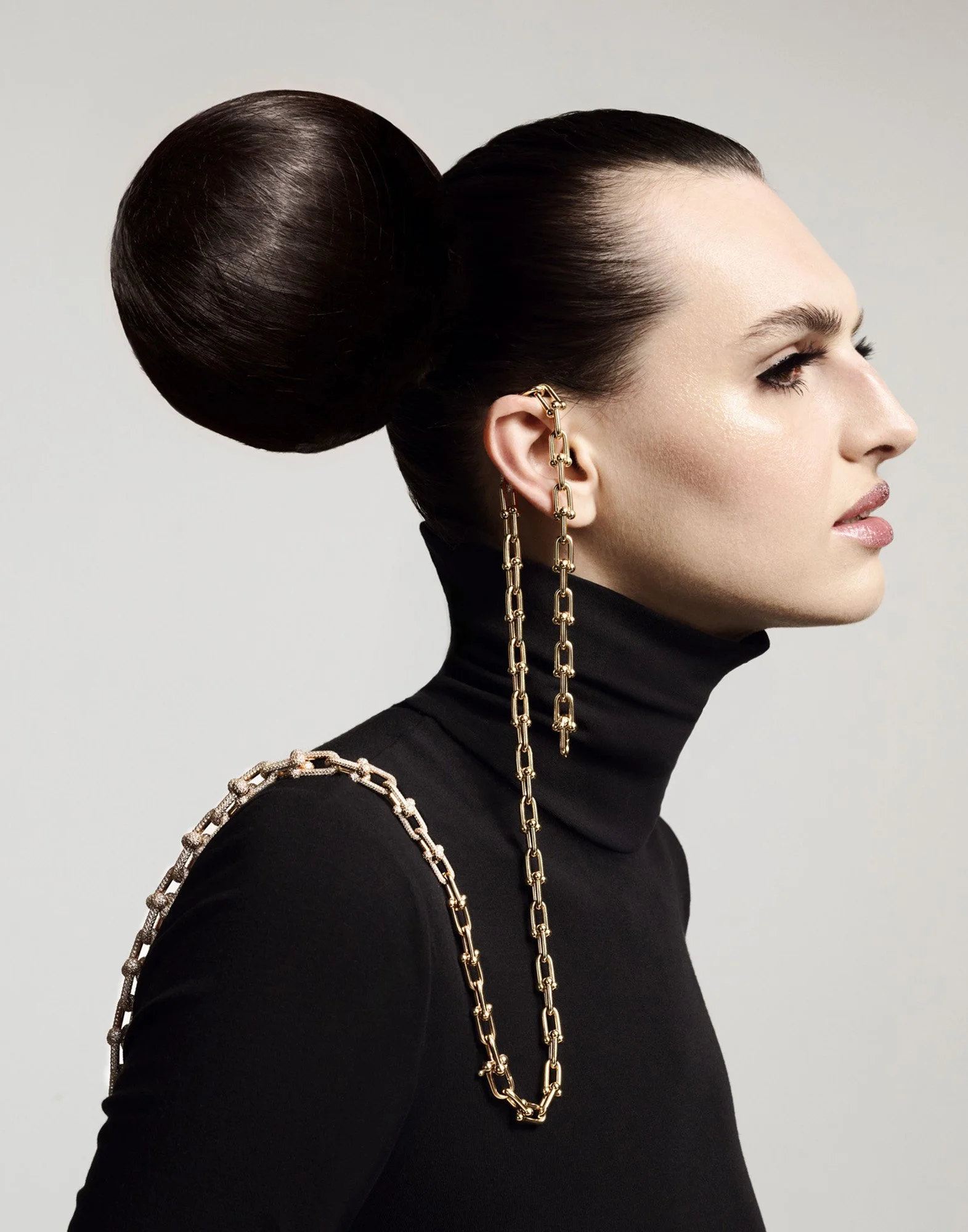 Jewellery profile — gold chain earring and sleek bun