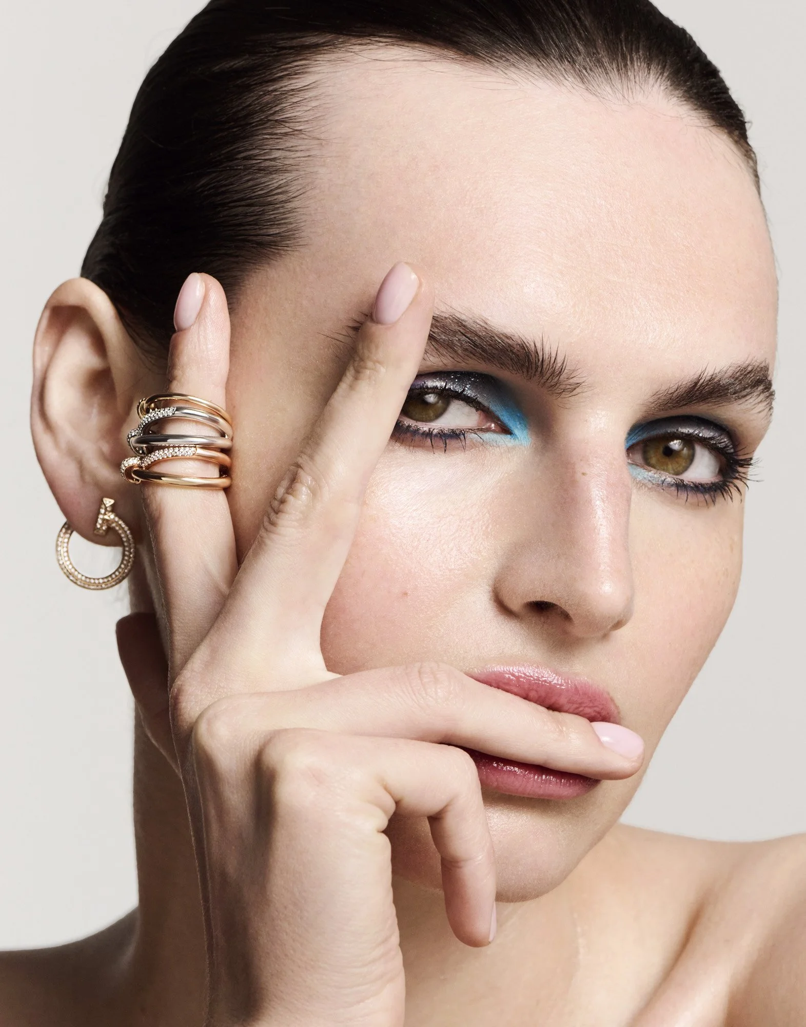 Stacked rings and ear jewellery, blue liner, jewellery photographer London Benjamin Kaufmann