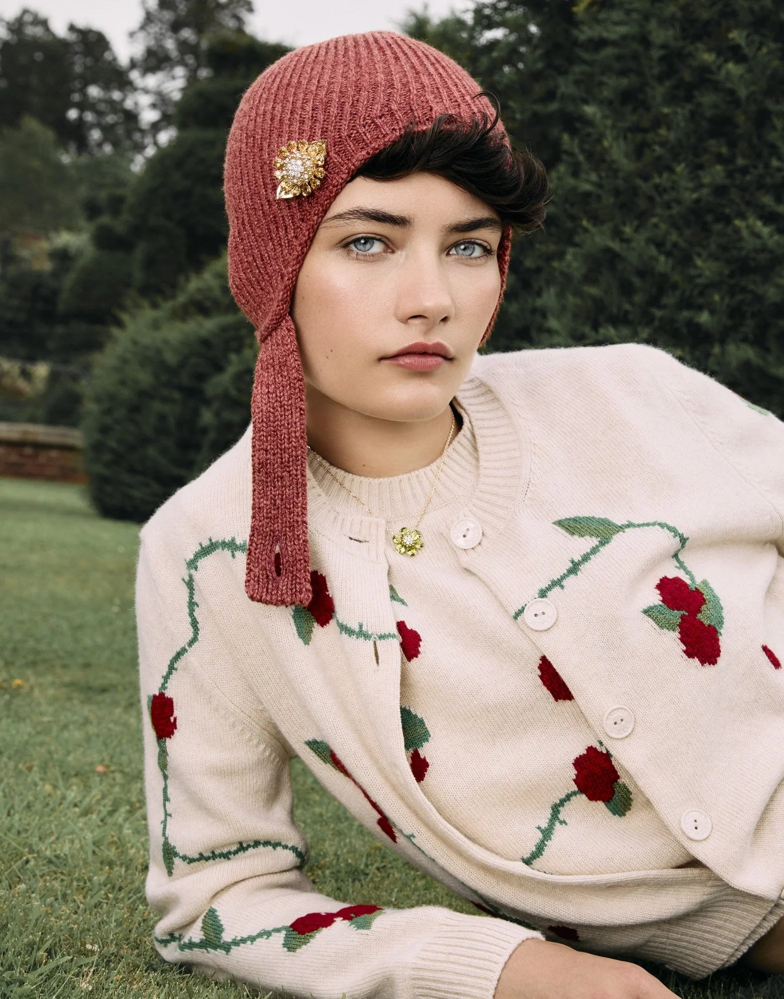 Knitted hat and brooch in a garden, accessories photography by Benjamin Kaufmann