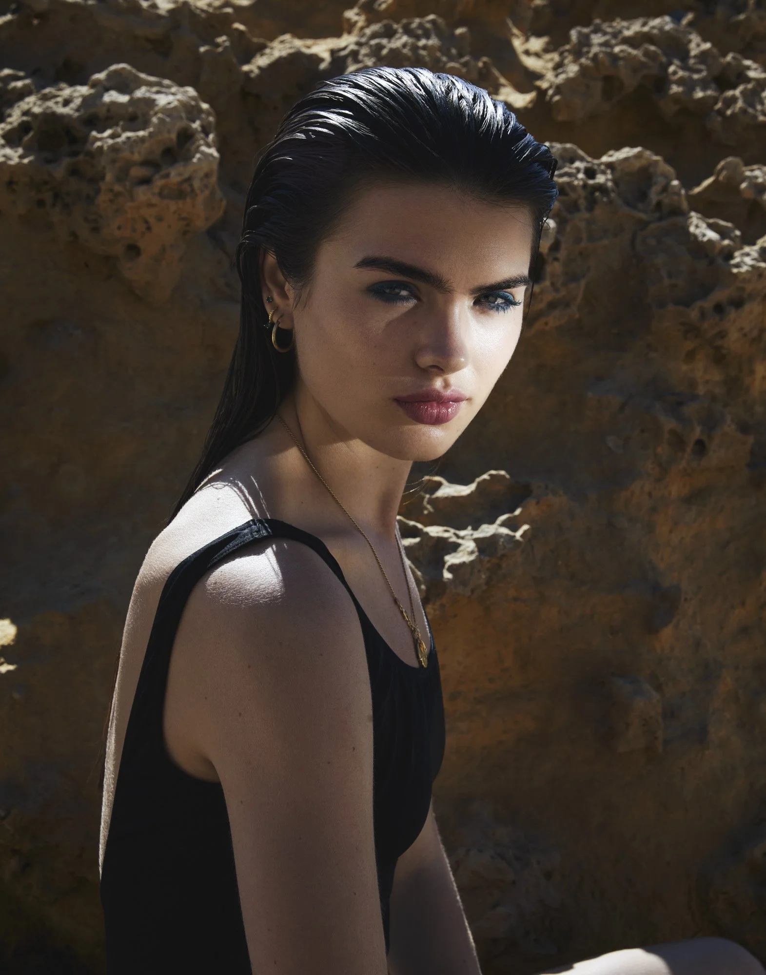 Teal eyeliner and wet-look hair in sunlight, beauty photography by Benjamin Kaufmann
