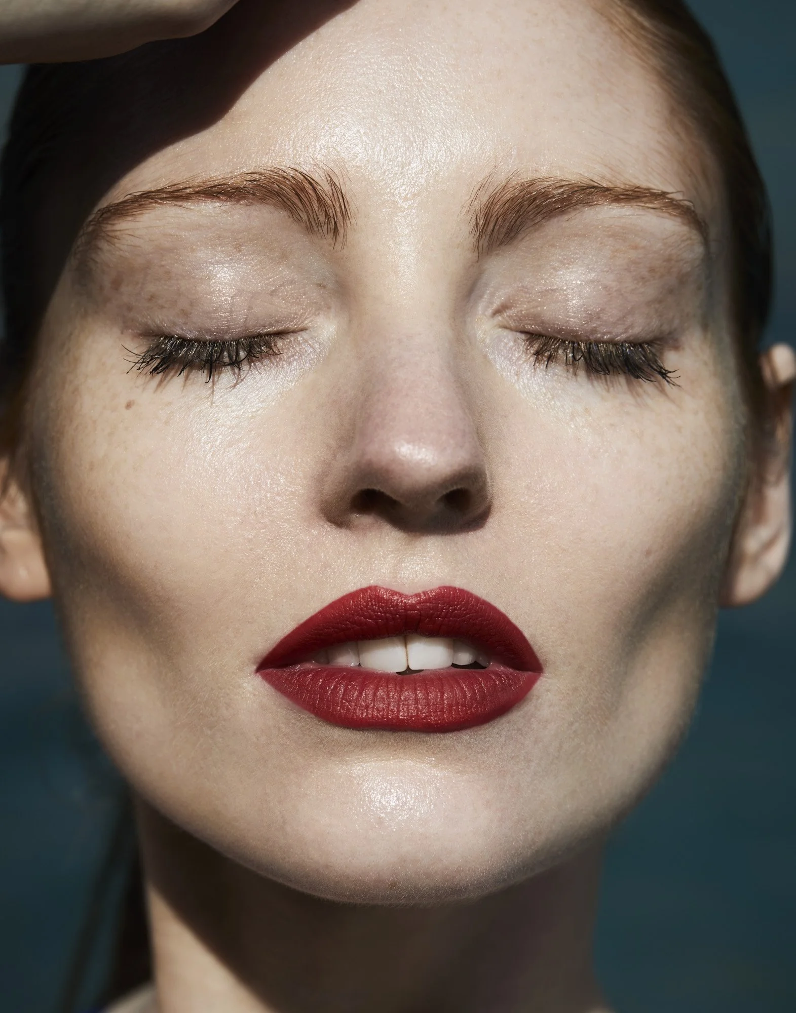 Red lips and closed eyes in sunlight, beauty photography London by Benjamin Kaufmann