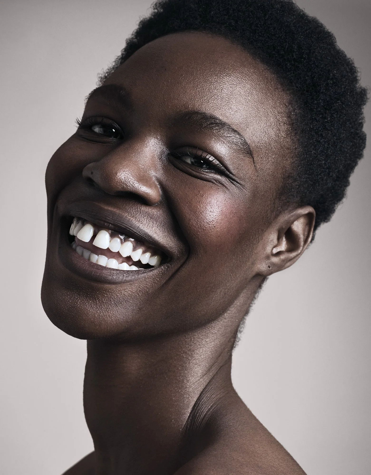 Wide smile and natural glow on deep skin, beauty photography London by Benjamin Kaufmann