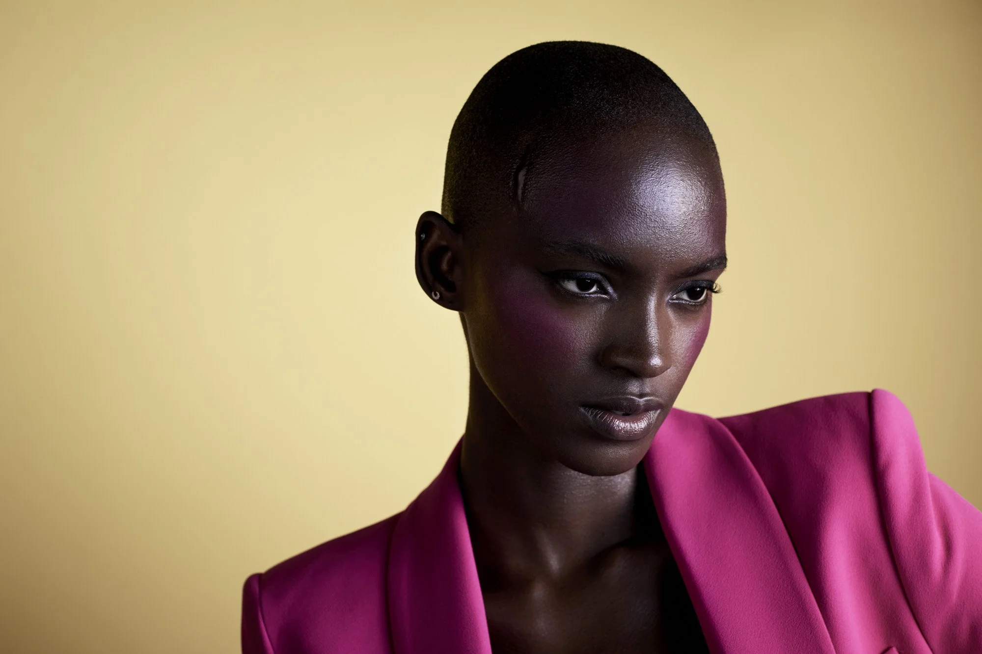 Violet eyeshadow on deep skin, magenta against yellow, colour beauty photography by Benjamin Kaufmann