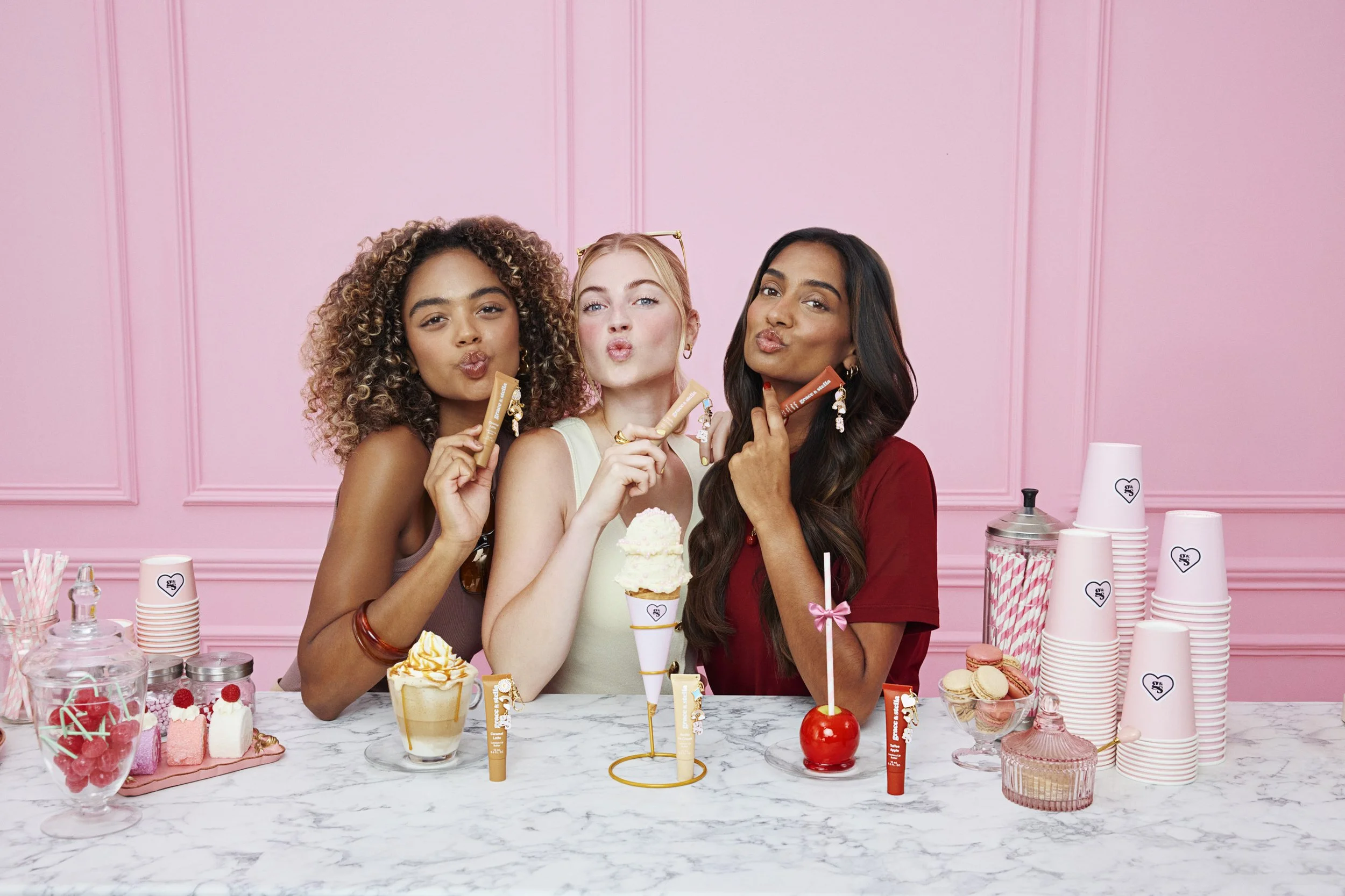 grace & stella Lip Butter Bar campaign: three models at the candy-pink butter bar, photographed by Benjamin Kaufmann