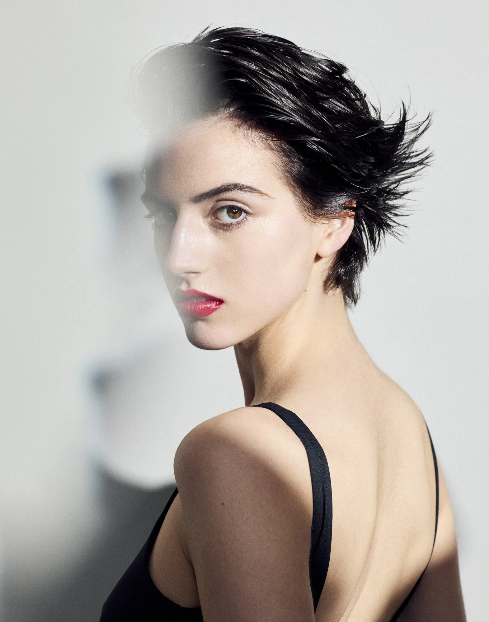 Short tousled hair and red lip through in-camera haze, editorial beauty photography by Benjamin Kaufmann