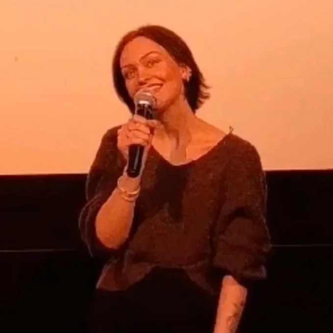 River the editor giving a speech at a mental health event at the cinema.