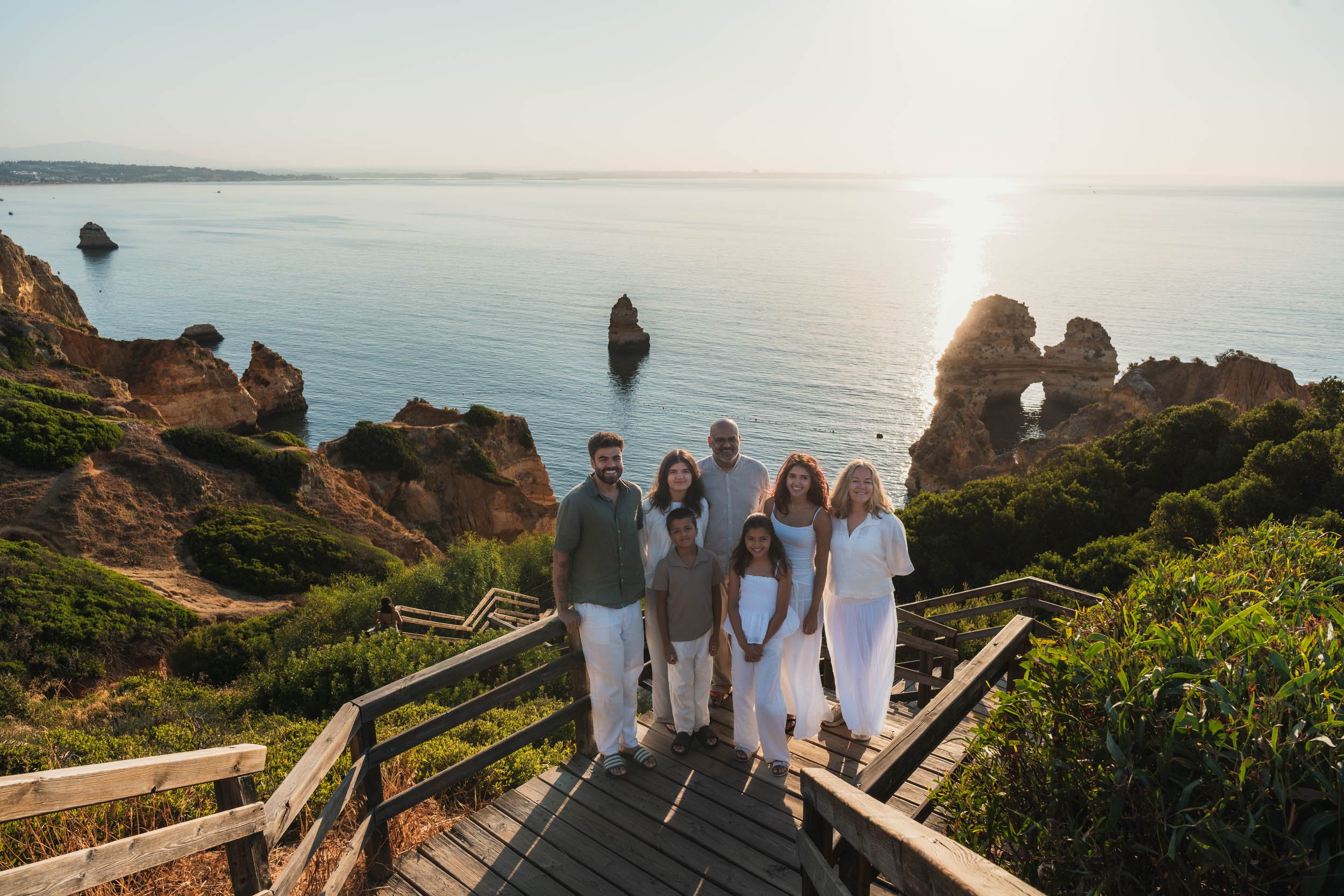 Family photoshoot at Praia do Camilo in Lagos, Algarve with cliffs and ocean view at sunrise.