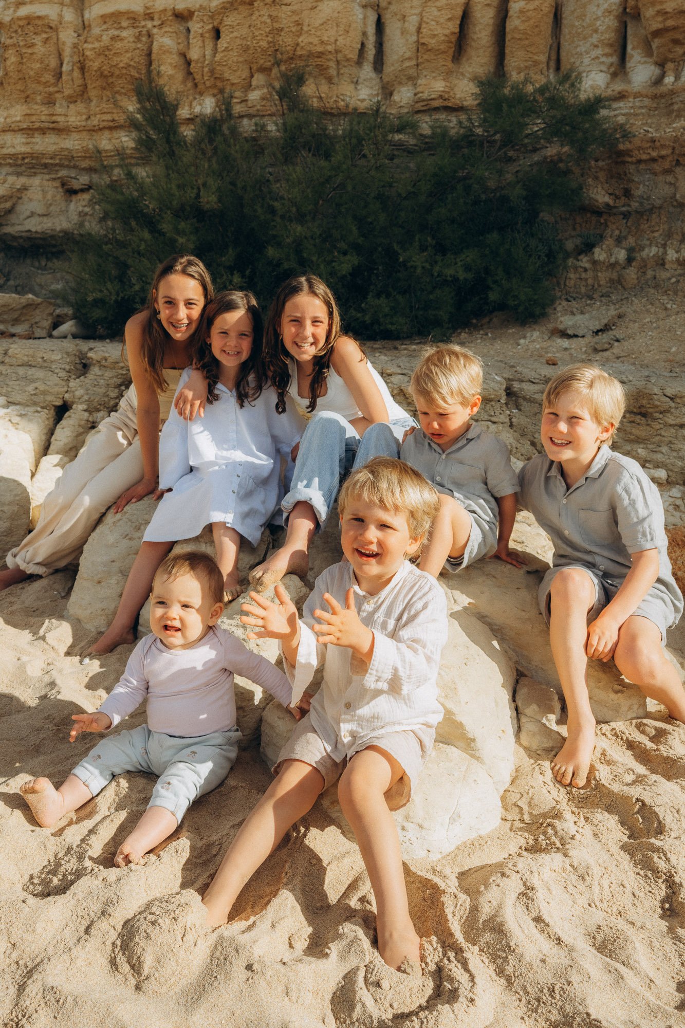 Large group of siblings and cousins laughing on Algarve beach, natural family photography session