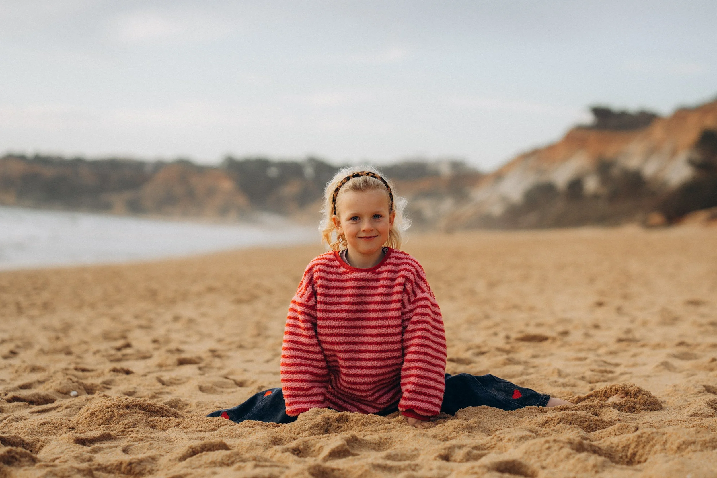 Girl playing in sand during Algarve family photoshoot at Praia da Falésia
