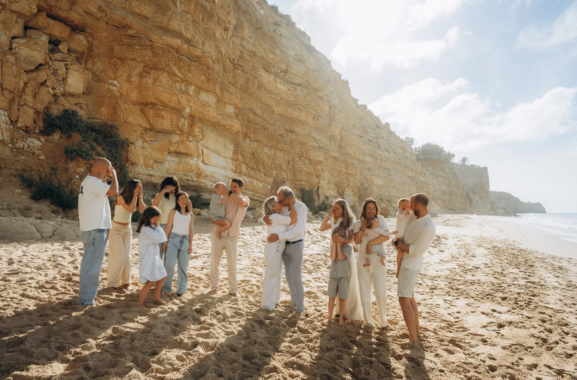 Extended family on Algarve beach with the ocean behind, a large family photography session in Portugal