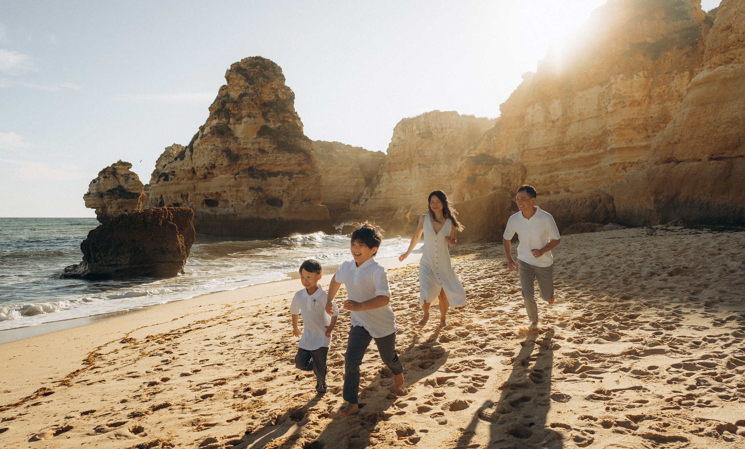 A family running at the beach. Photoshoot at Praia da Marinha