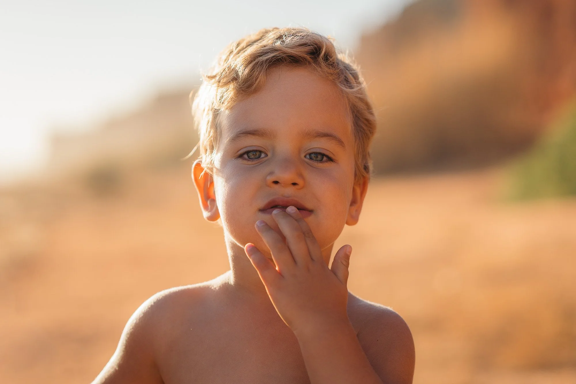 Portrait of a child on a scenic cliff in the Algarve coastline.