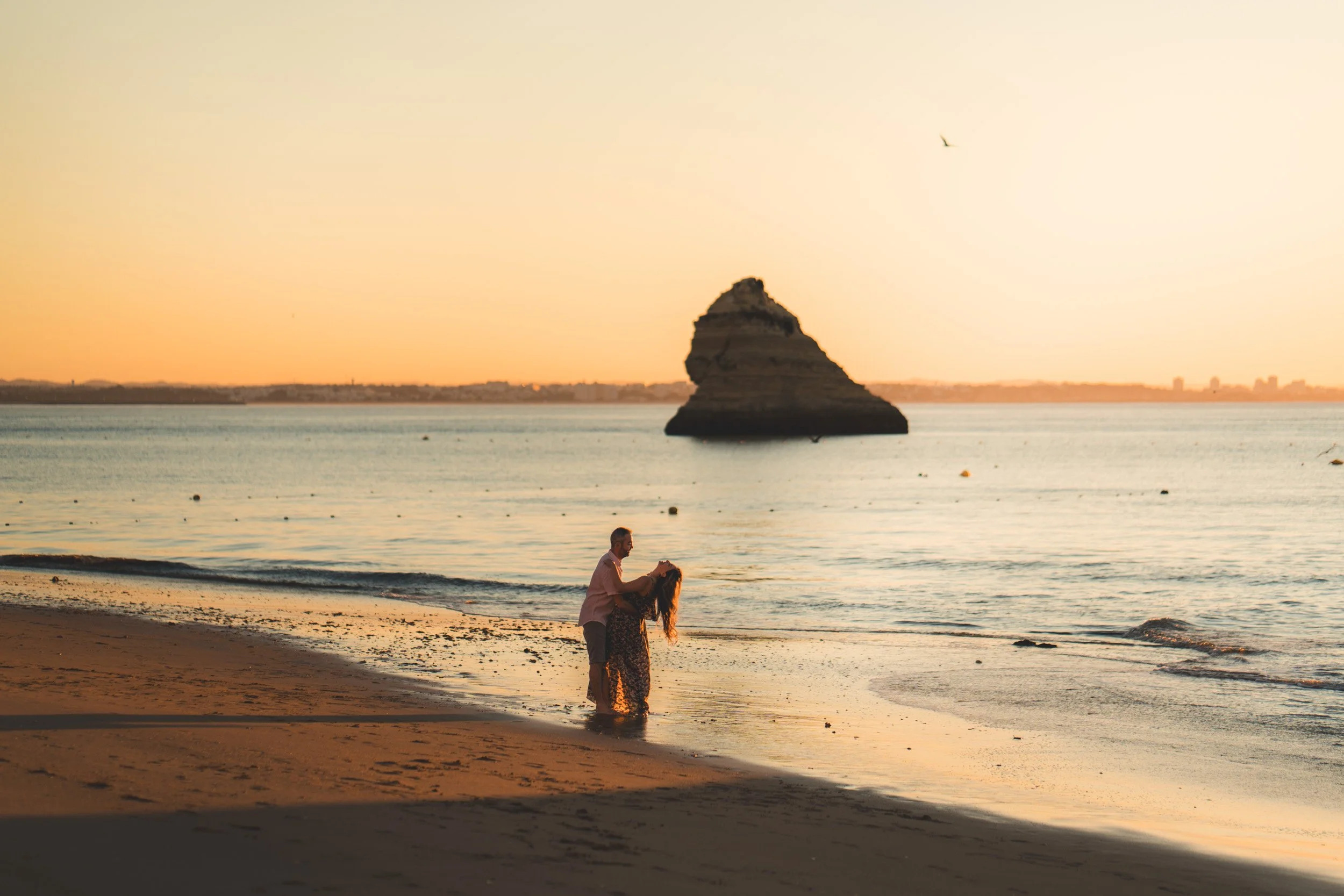 Intimate embrace near the cliffs of Lagos, romantic couple photoshoot at Praia Dona Ana during golden hour, Algarve