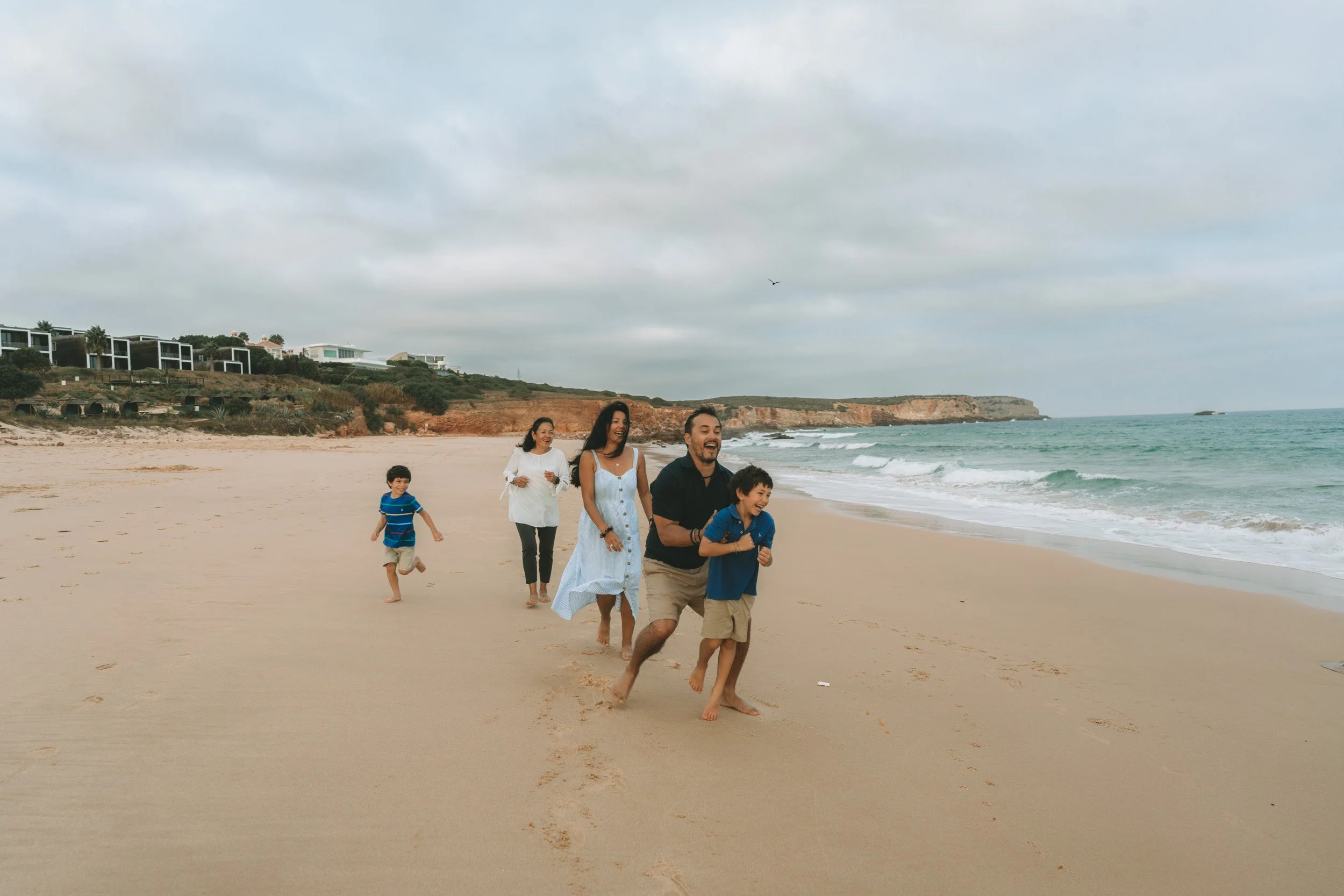 Kids running and playing on the sand, with the family following their natural energy instead of directing poses.