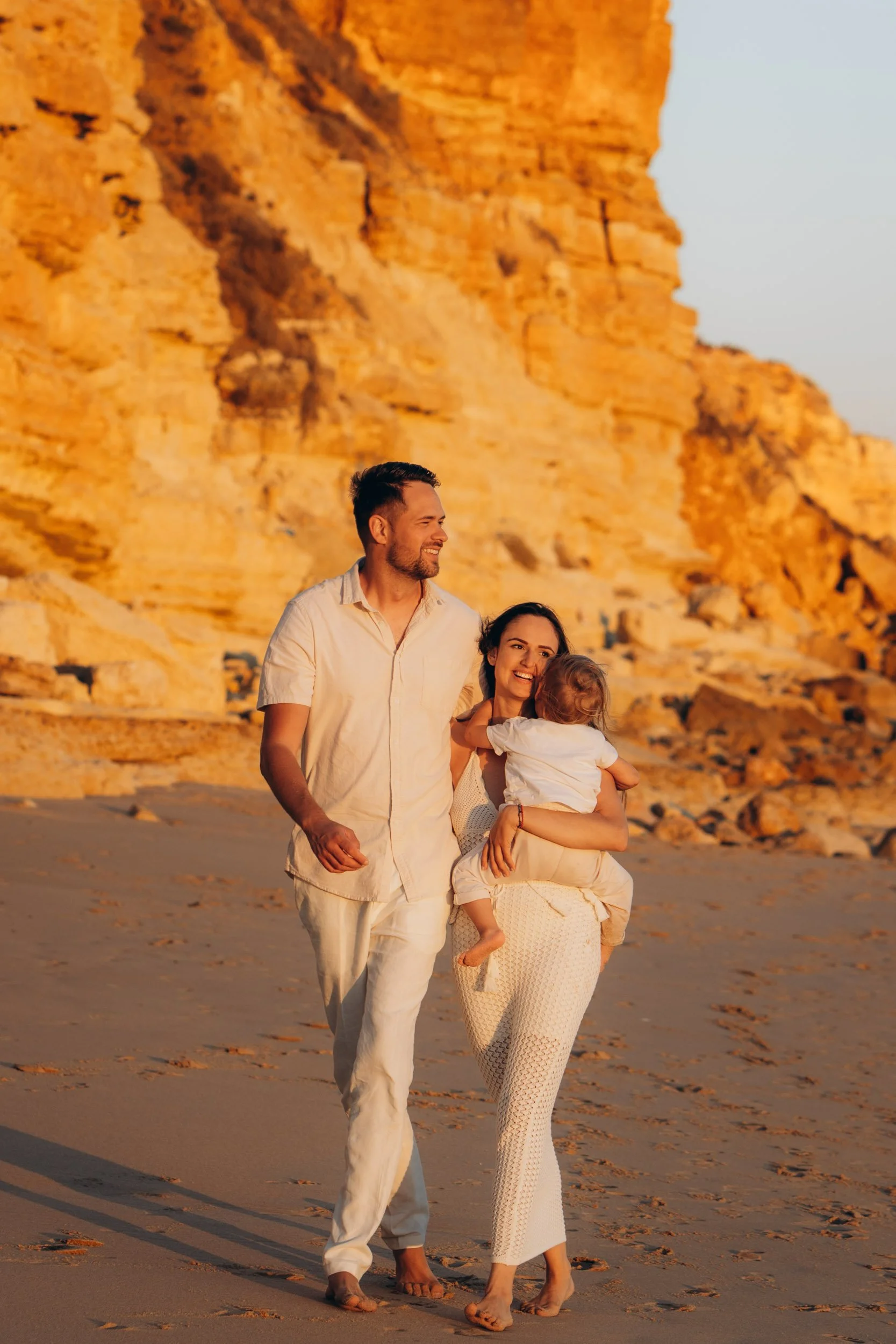 Family walking along cliffs during golden hour — Algarve family photographer session