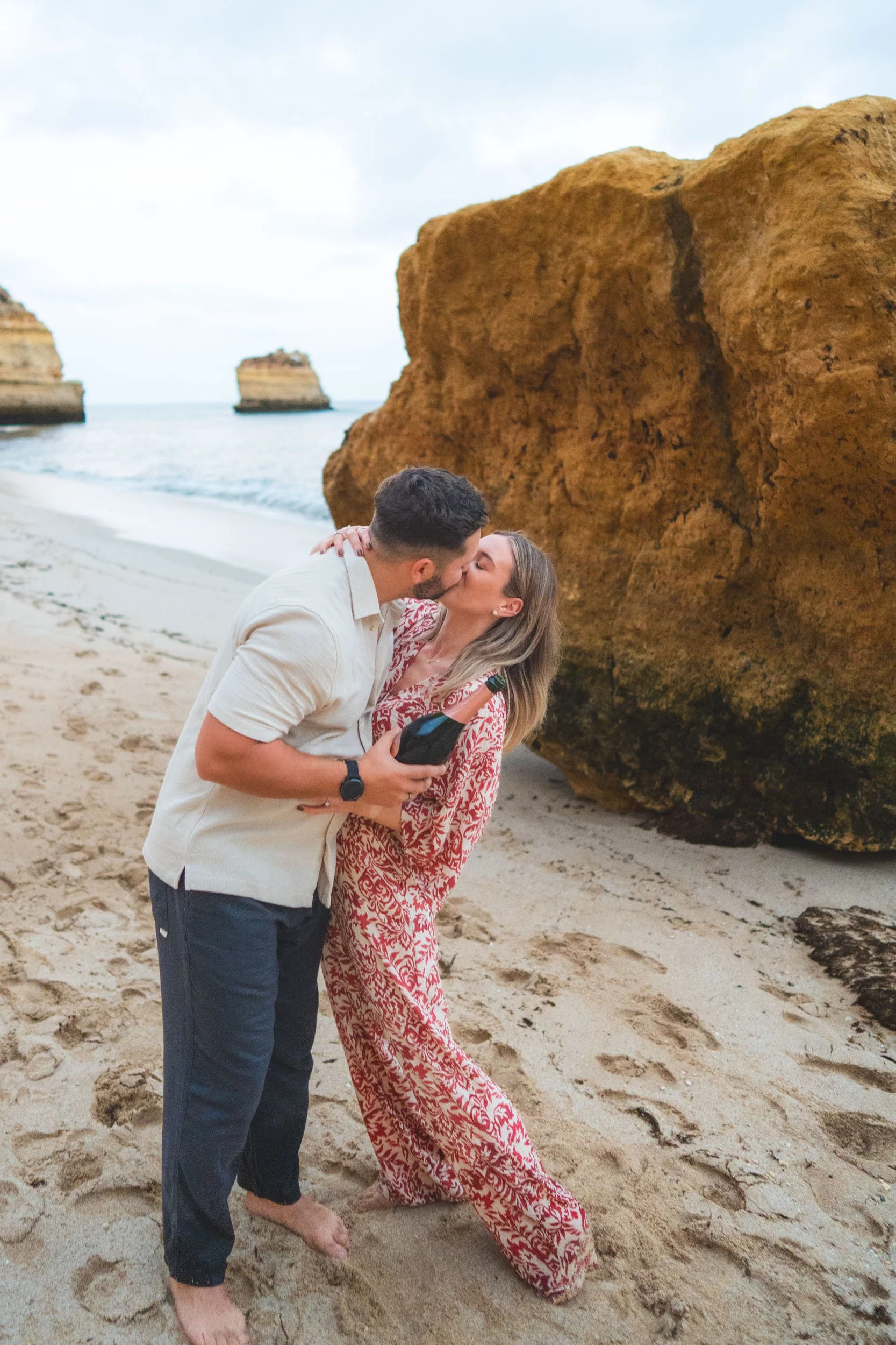 Engagement celebration on Praia da Marinha beach in the Algarve, with champagne toast and intimate sunset atmosphere.